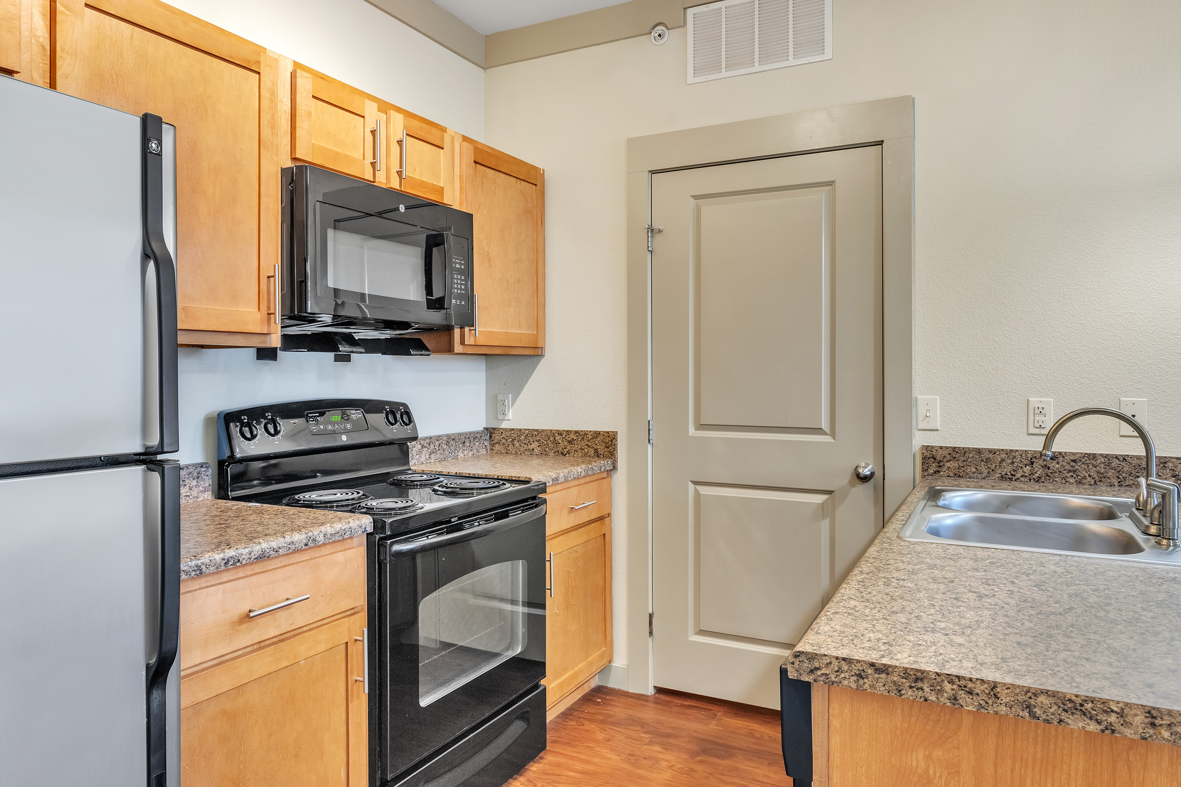 kitchen with laundry room microwaved and oven Riverside at Rockwater Luxury Apartments North Little 