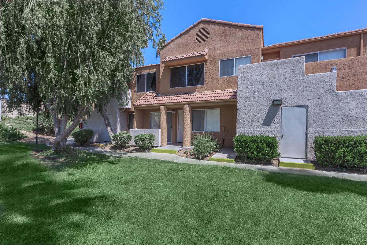 a large brick building with grass in front of a house