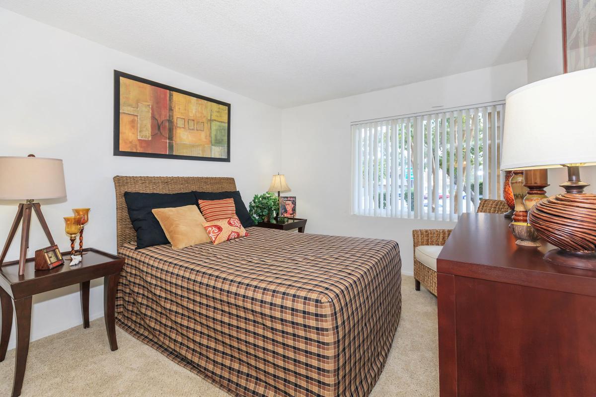 a bedroom with a bed and a chair in a room
