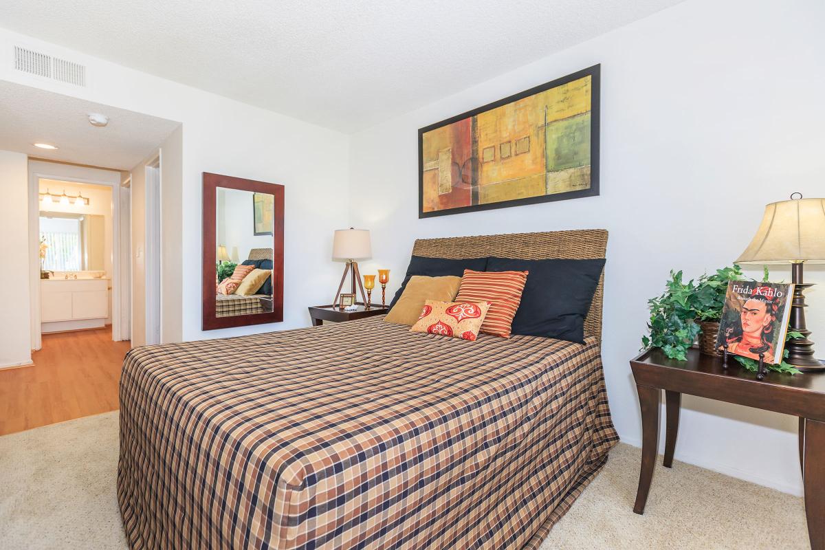 a bedroom with a bed and a chair in a room