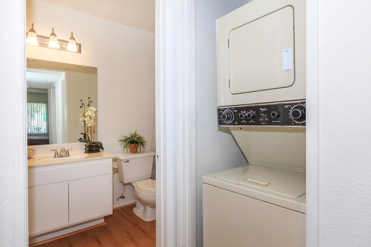 a white sink sitting under a mirror