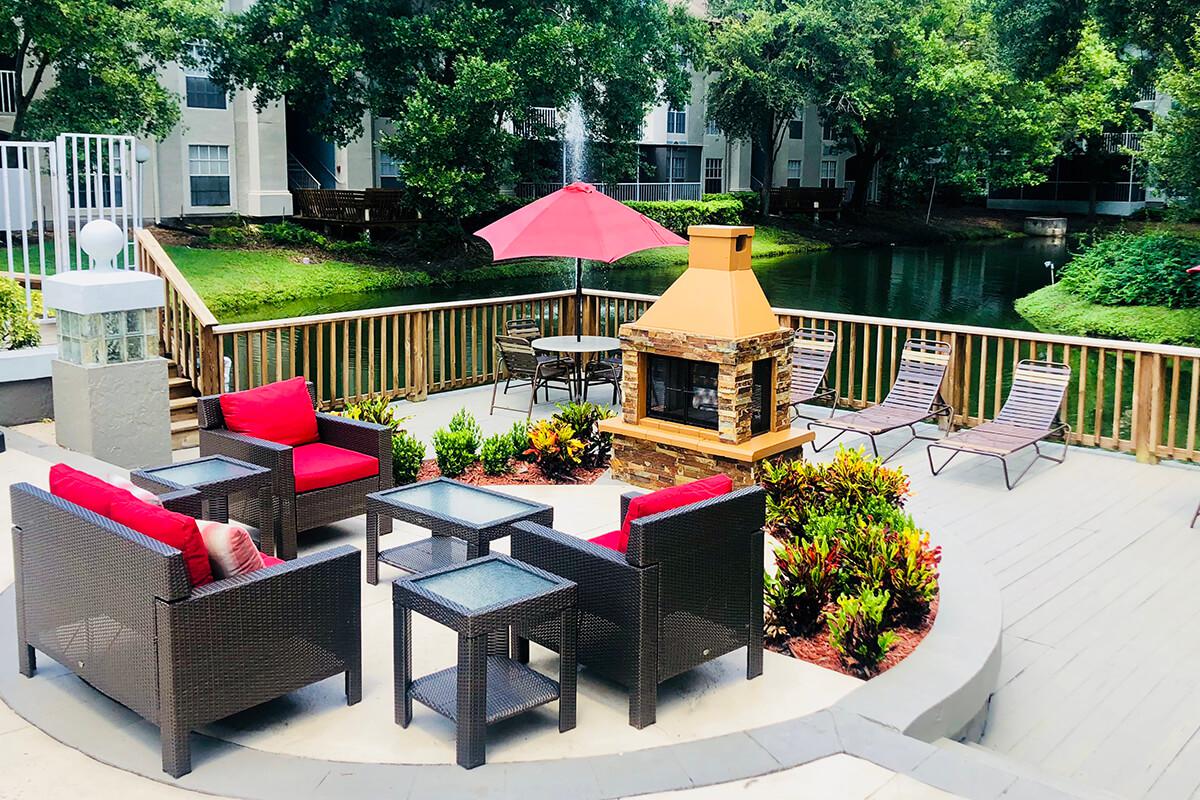 a group of lawn chairs sitting on top of a red umbrella