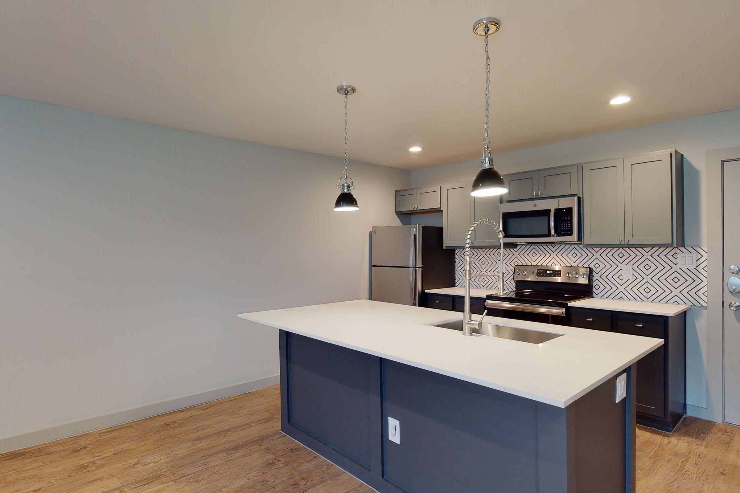a vacant kitchen with white countertops