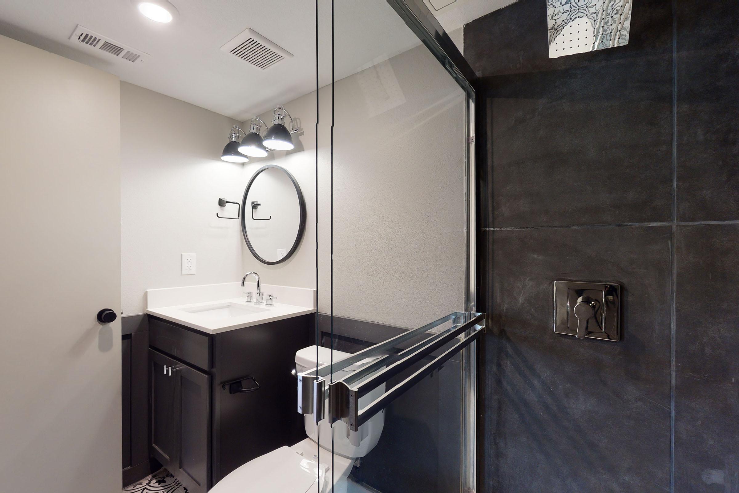 an unfurnished bathroom with black shower tiles