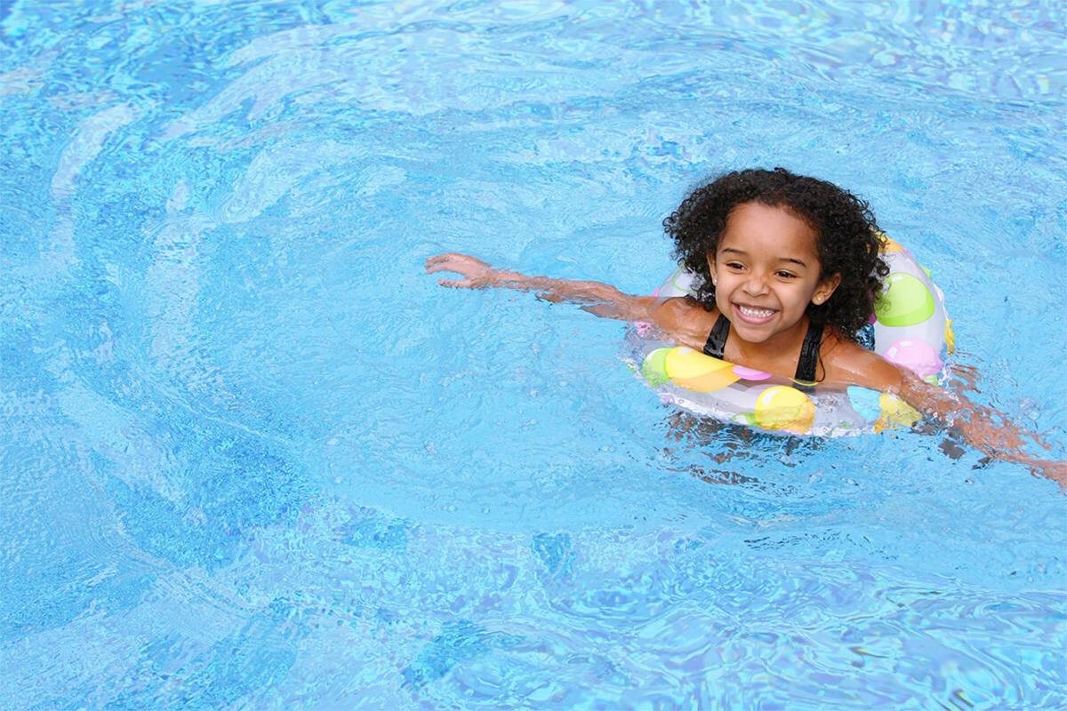 a young girl riding a wave on a surfboard in the water