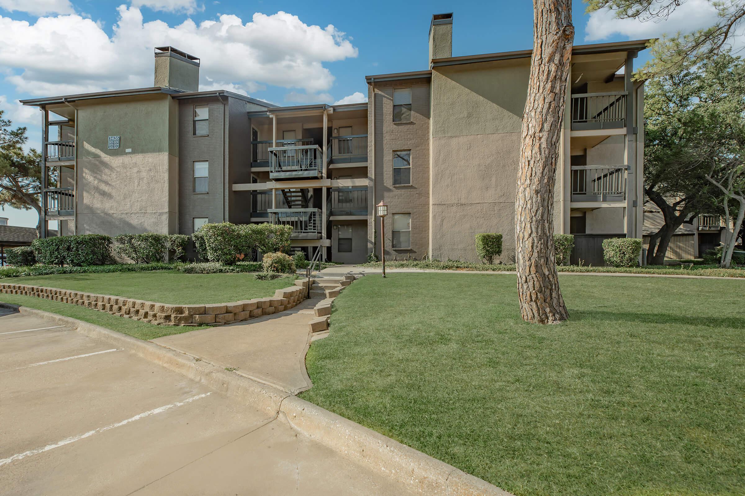 a large lawn in front of a brick building