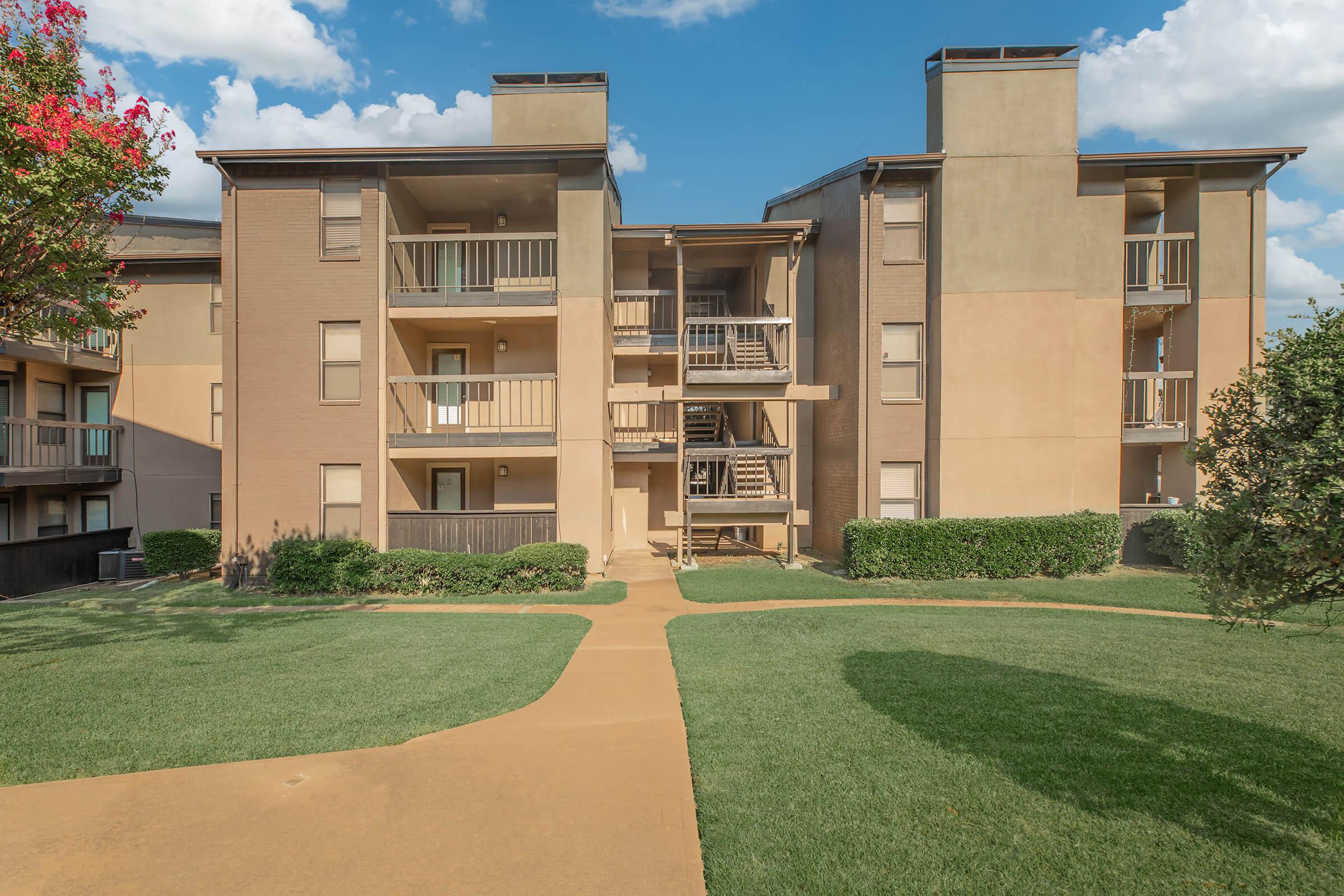 a large lawn in front of a brick building