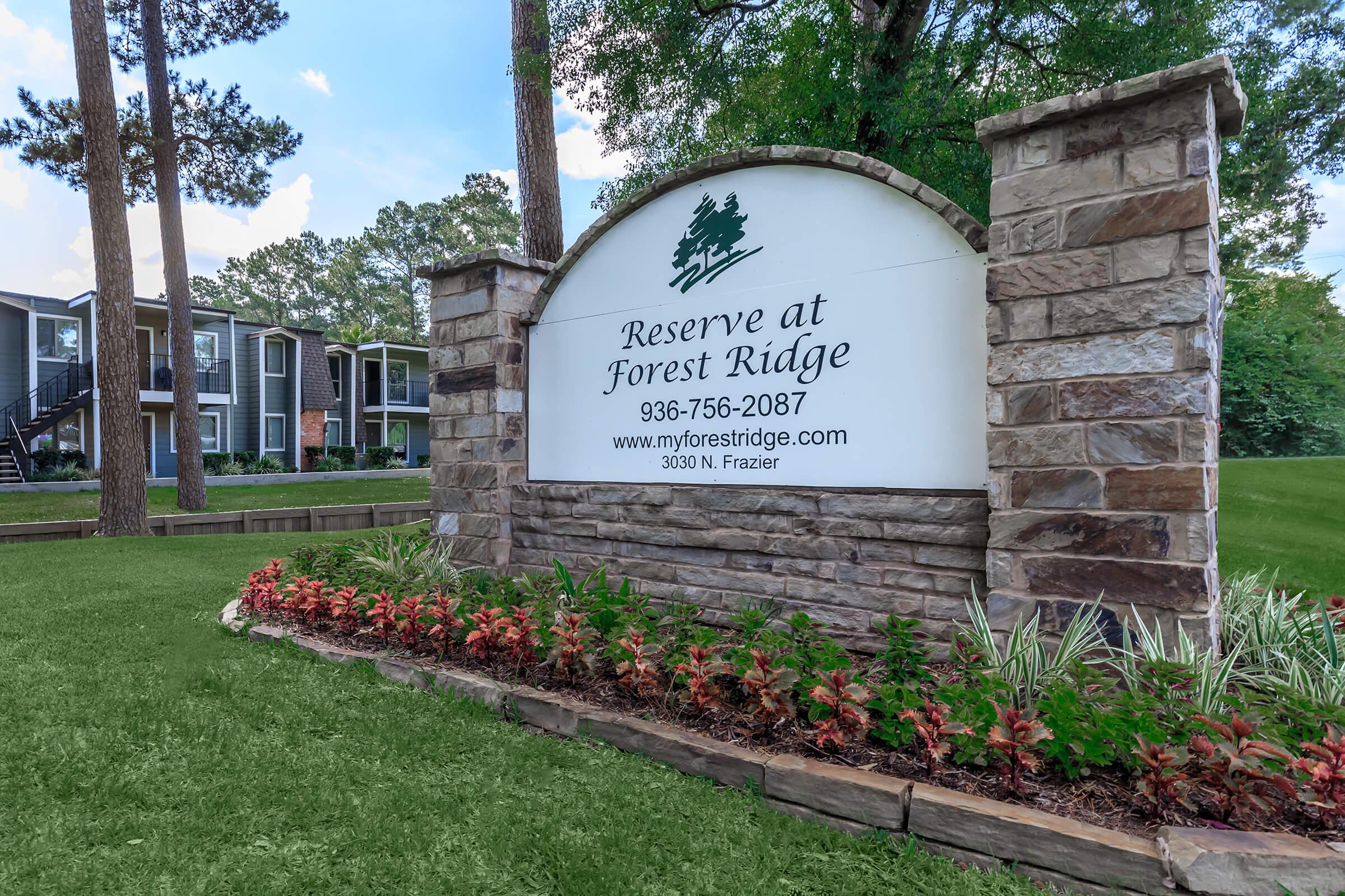 a close up of a flower garden in front of a brick building