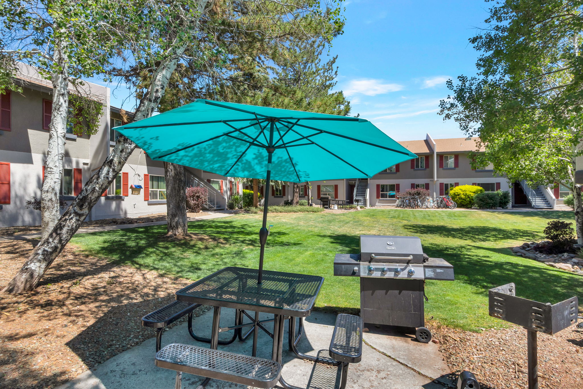 Enjoy sunny afternoons grilling and relaxing under vibrant umbrellas in our beautifully landscaped courtyard, perfect for both casual gatherings and quiet moments.