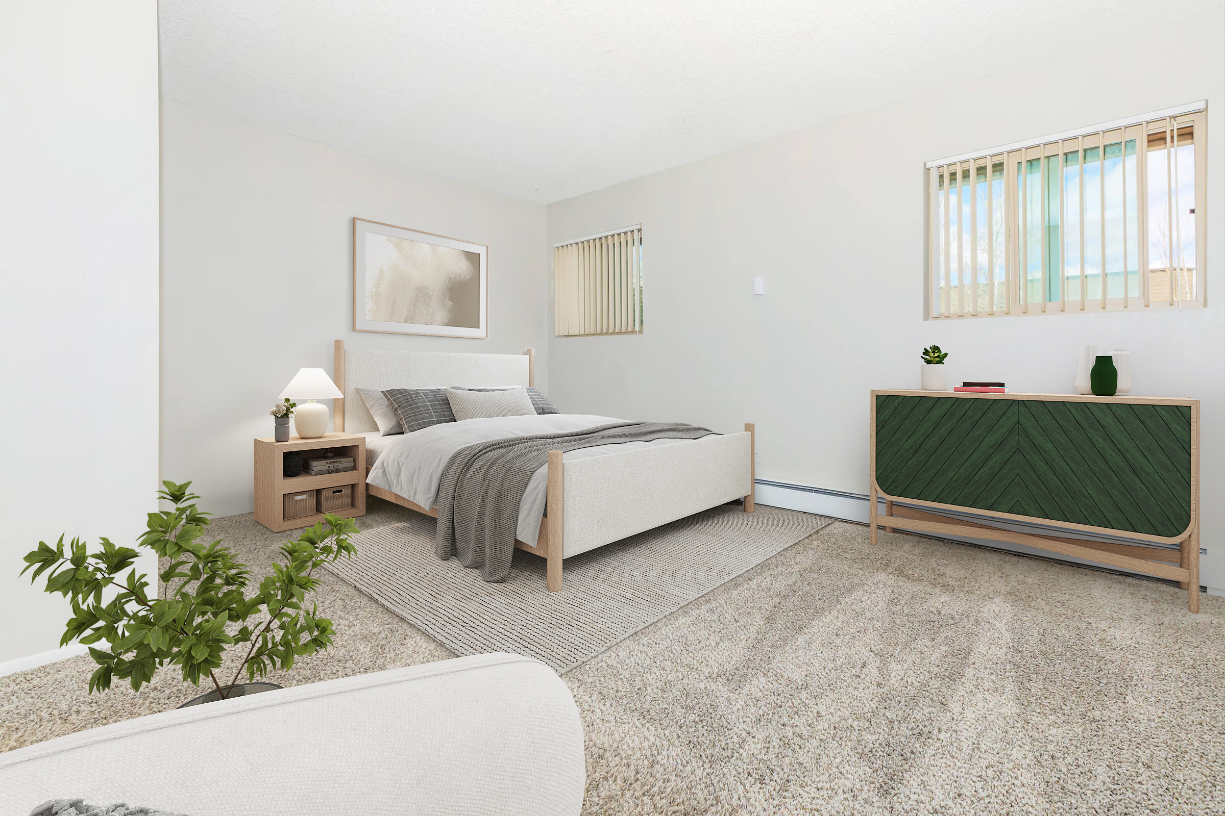 A cozy bedroom featuring a light-colored bed with gray bedding, a small nightstand with a lamp, and a green accent dresser. Natural light filters through two windows with blinds. A plant adds a touch of green, and the carpeted floor enhances the warm, inviting atmosphere.