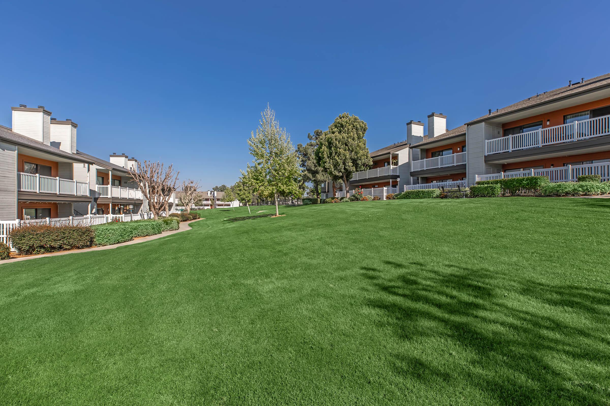 a large green field in front of a building