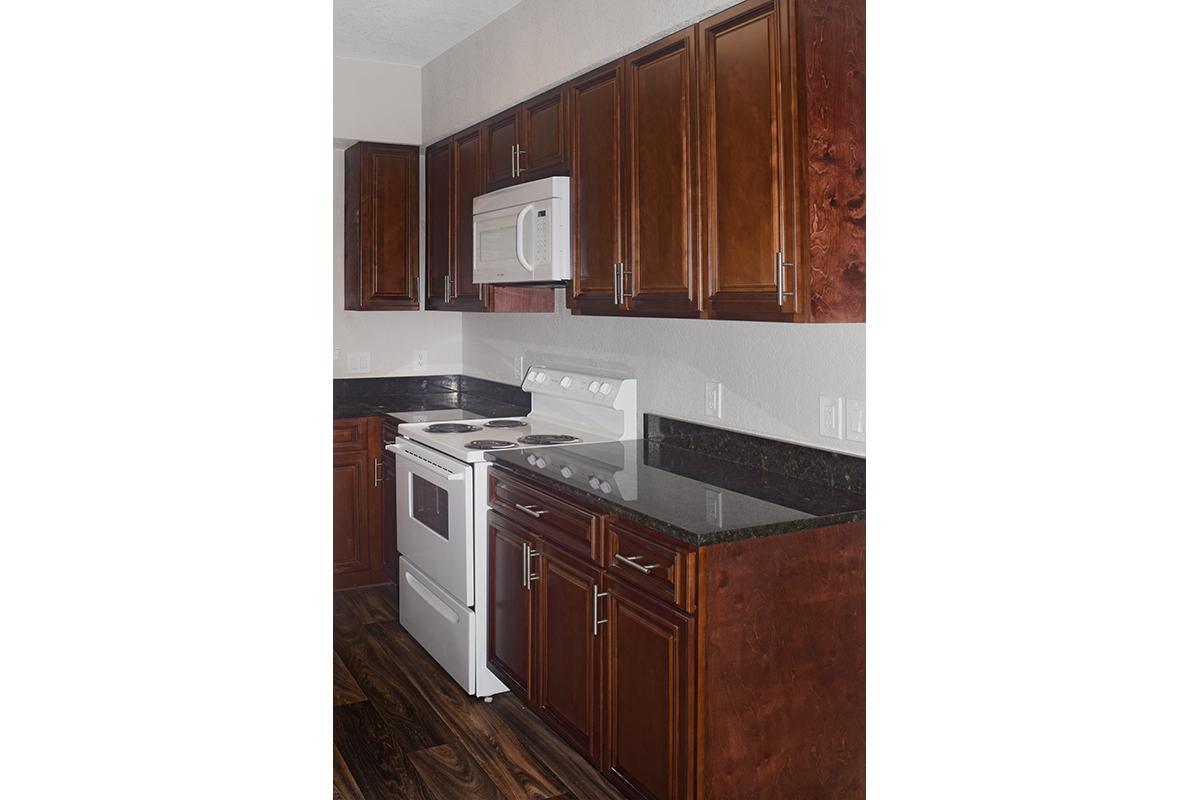 a kitchen with wooden cabinets and a microwave