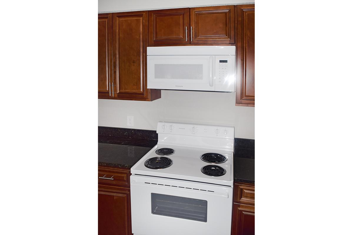 a white stove top oven sitting inside of a kitchen