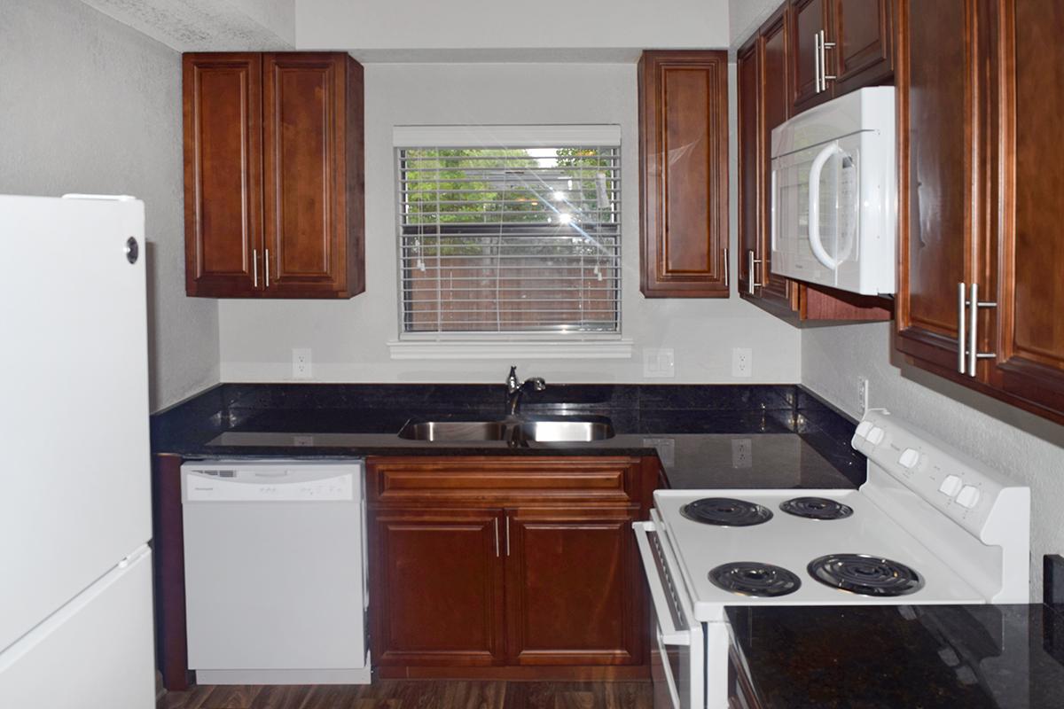 a kitchen with wooden cabinets and a black stove top oven