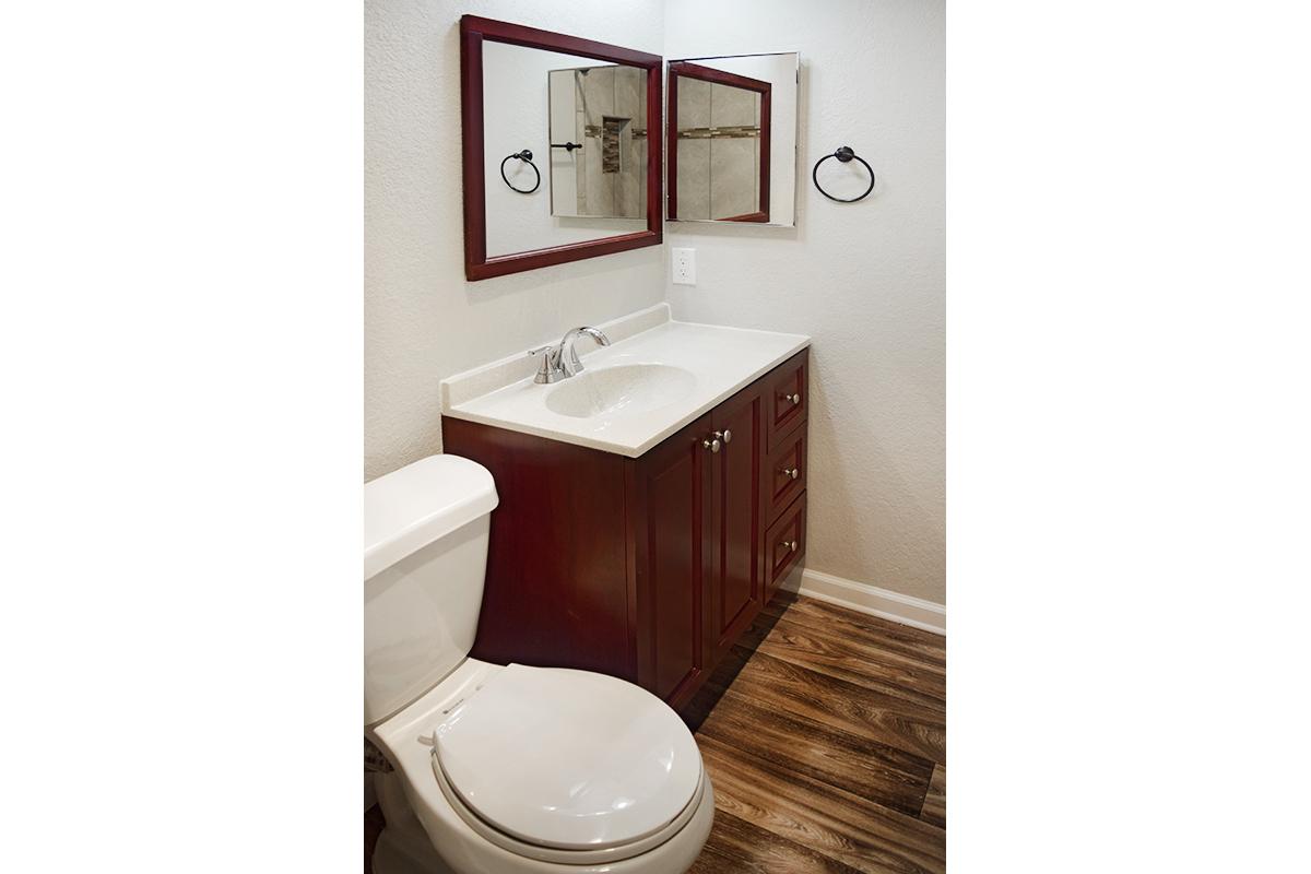 a white sink sitting under a mirror