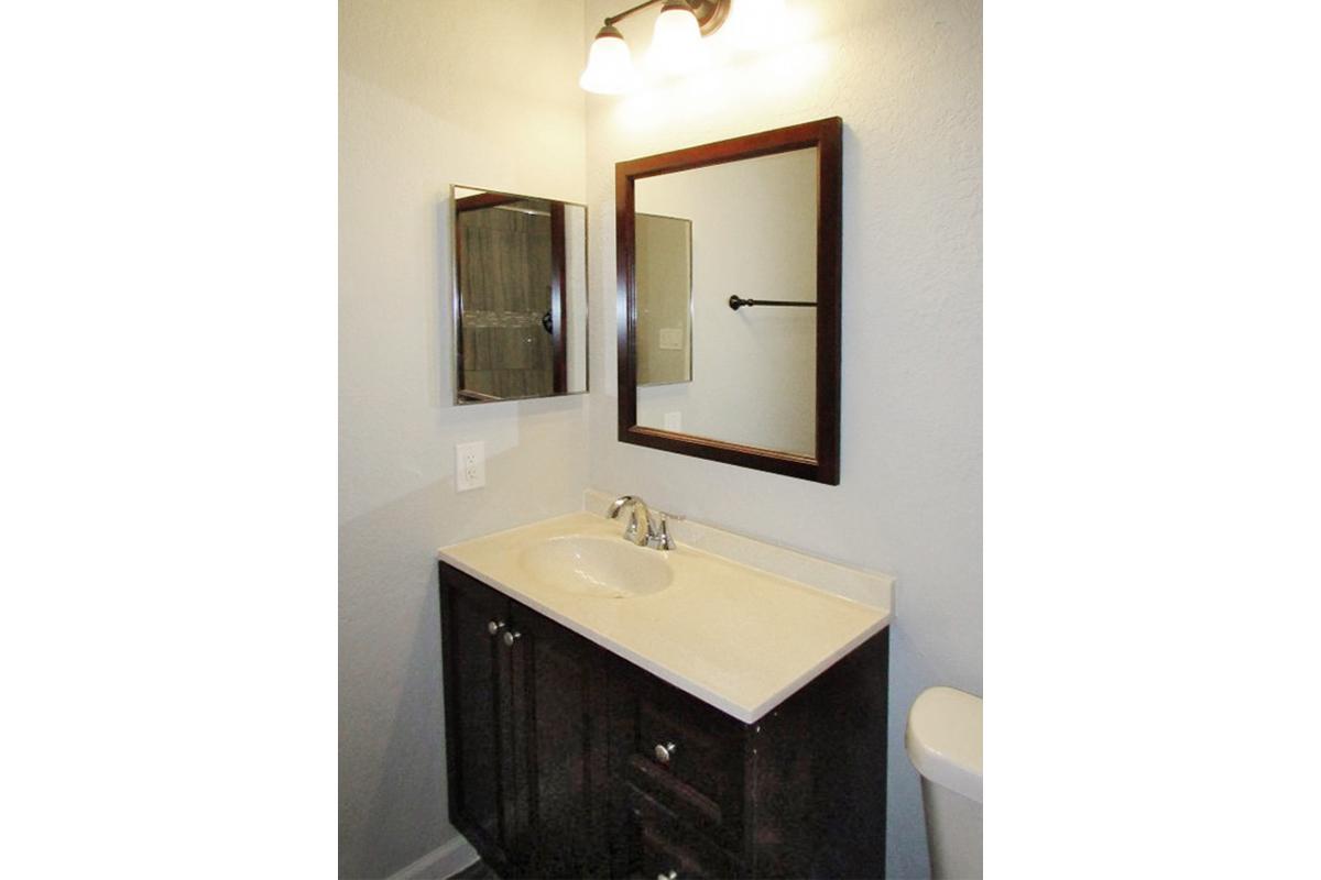 a white sink sitting under a mirror