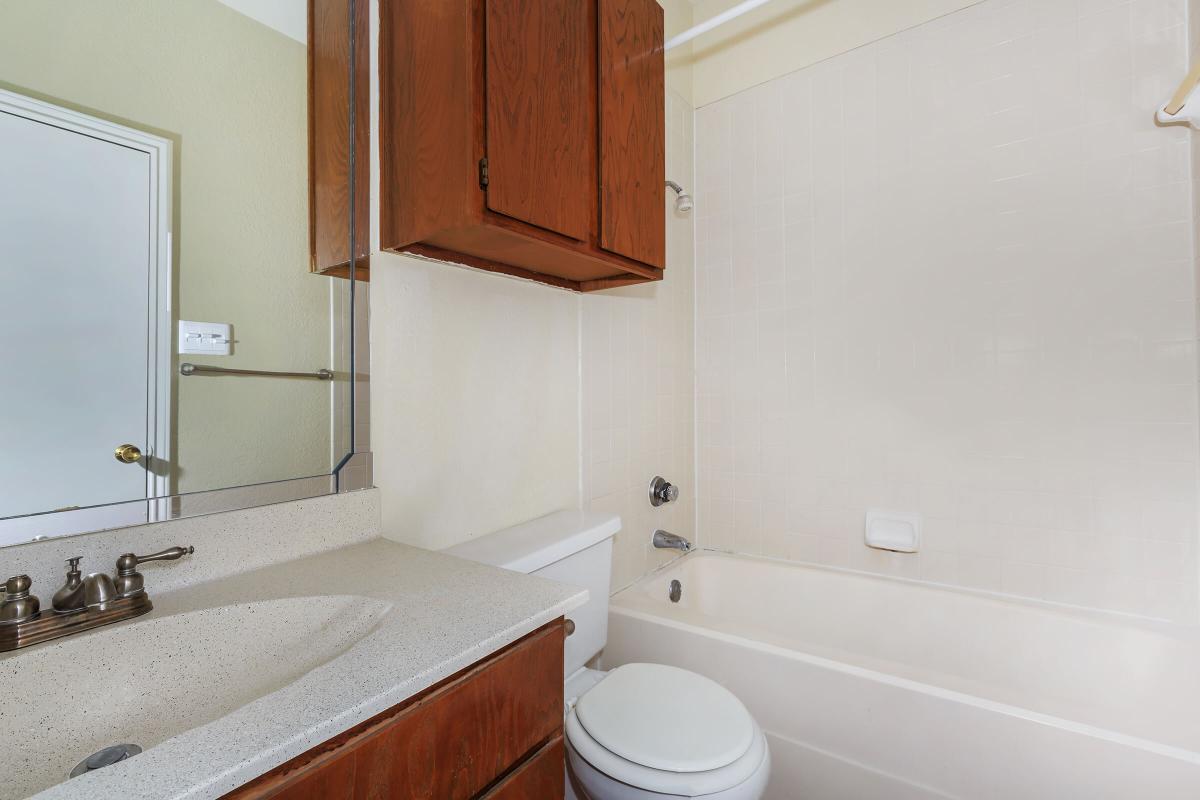 a white sink sitting next to a shower