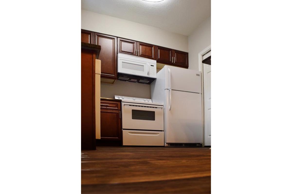 a kitchen with white appliances and wooden cabinets