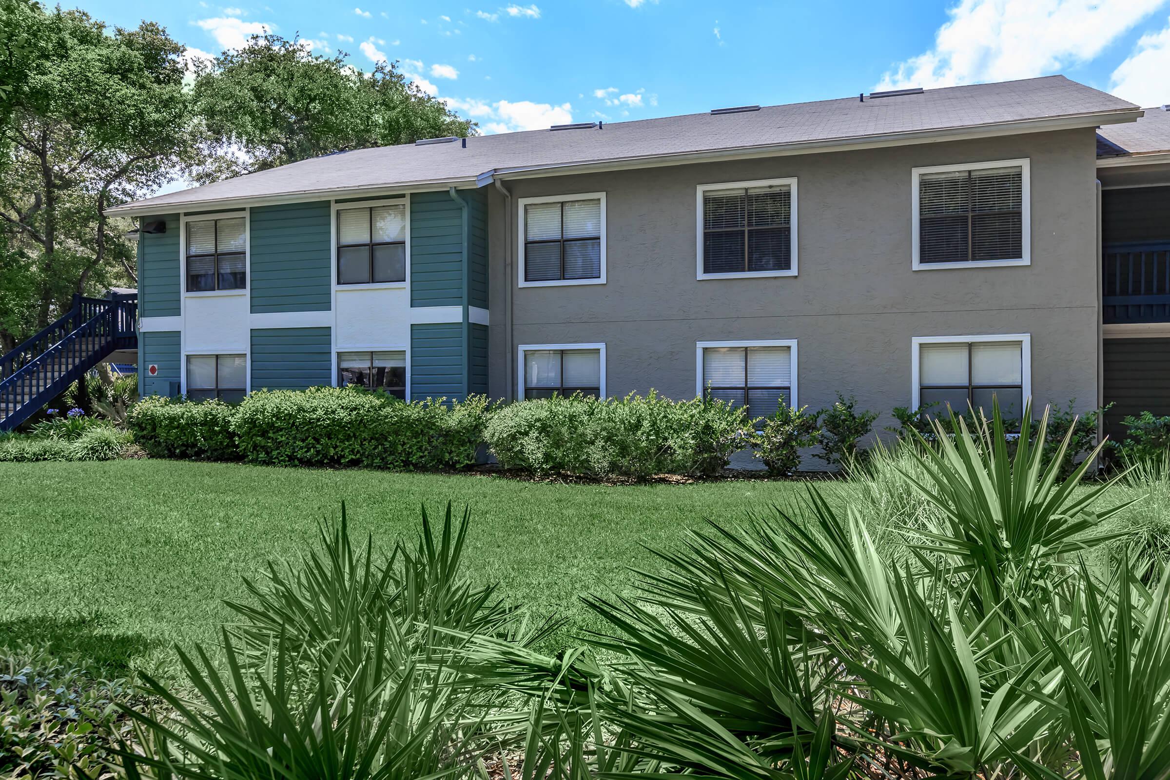 a house with bushes in front of a building