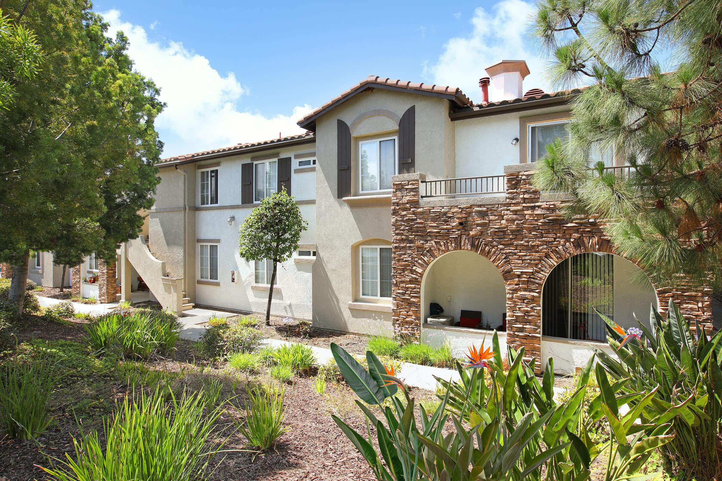 a house with bushes in front of a building