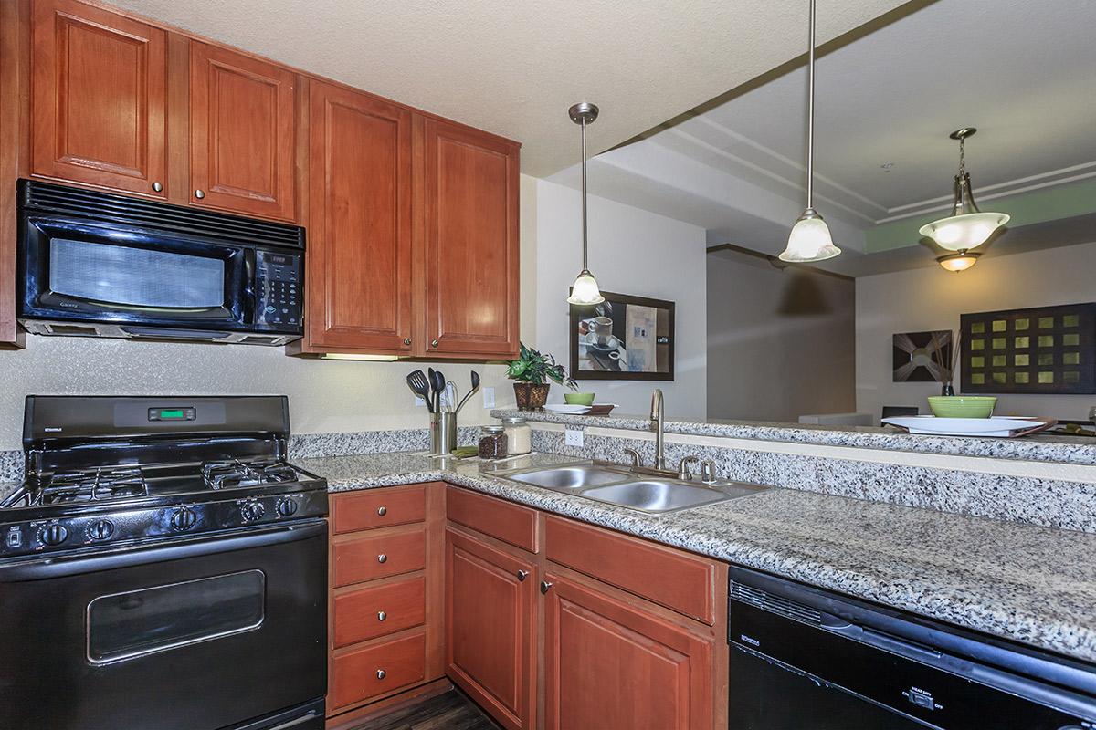 a large kitchen with stainless steel appliances and wooden cabinets