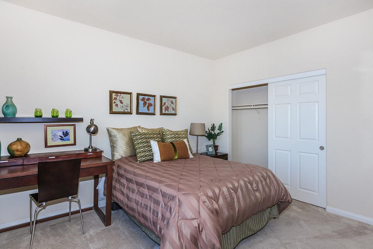 a bedroom with a bed and desk in a room