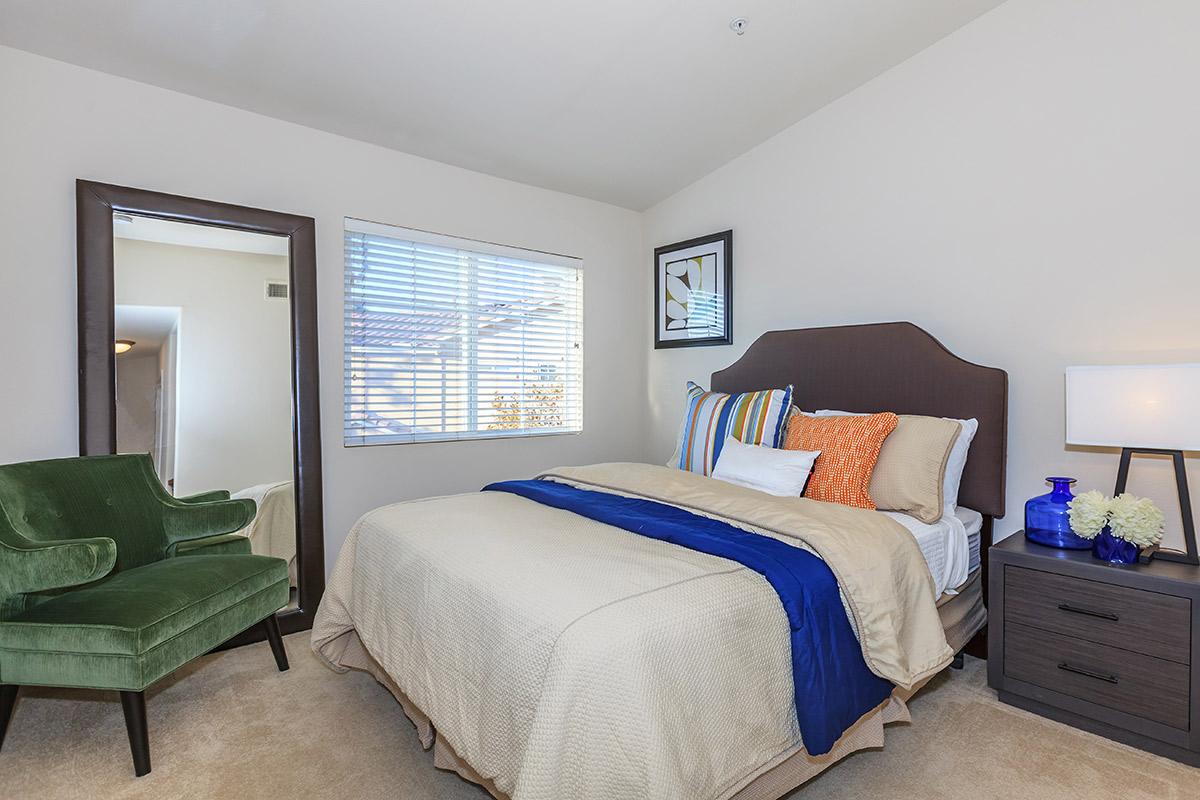 a bedroom with a bed and desk in a room