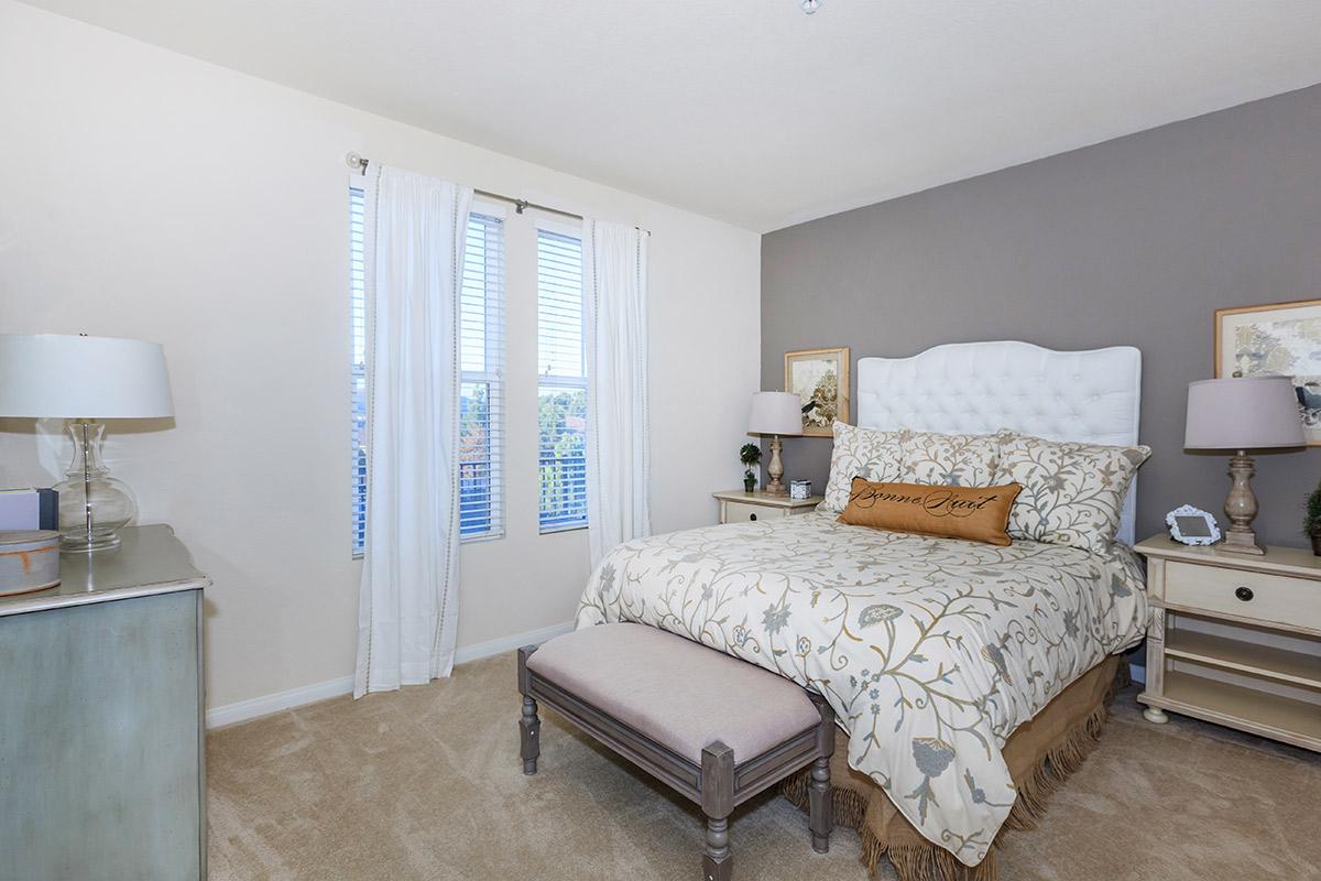 a bedroom with a bed and desk in a room