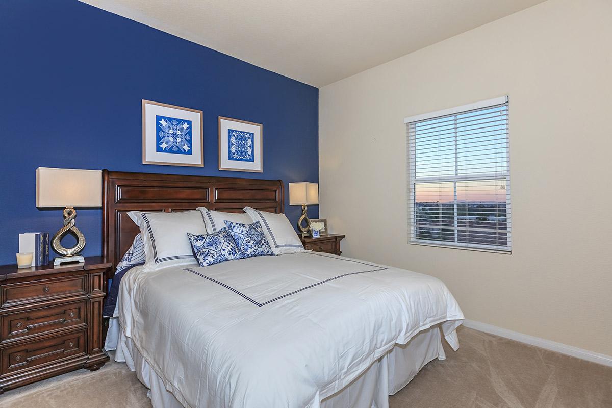 a bedroom with a bed and desk in a room