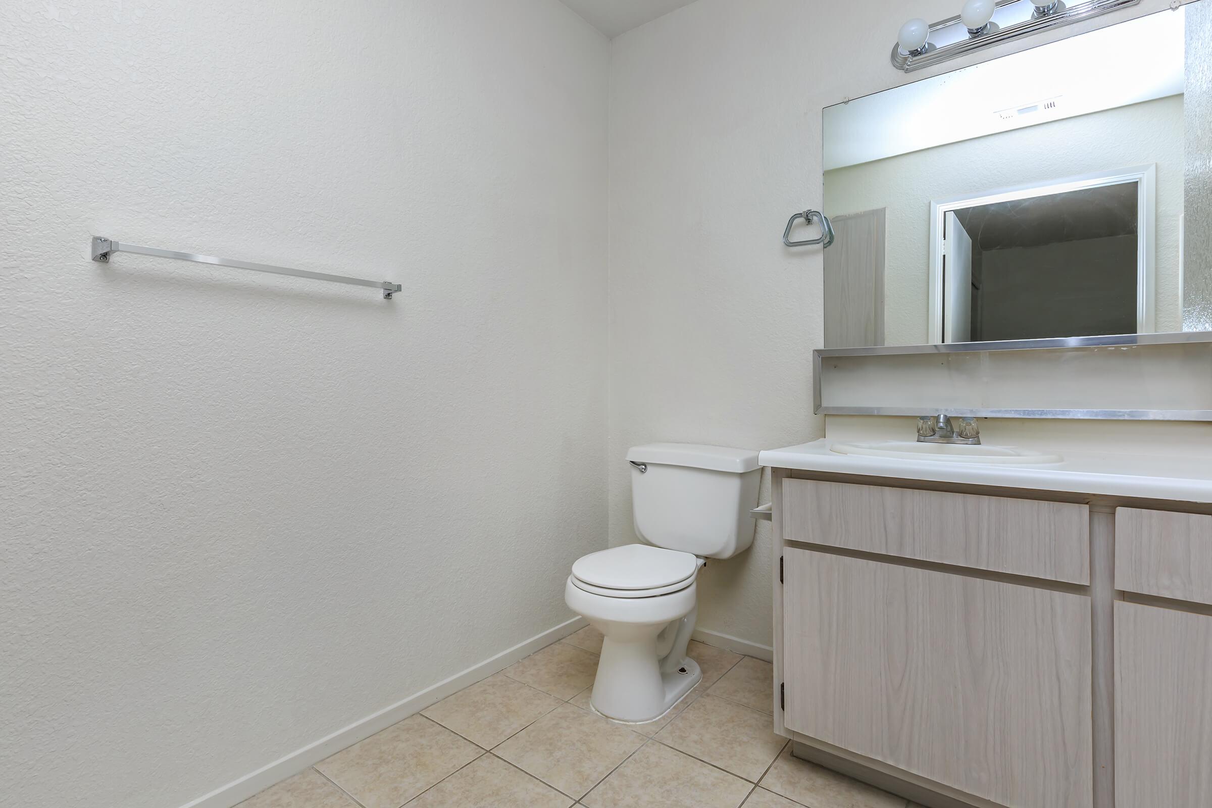 a white sink sitting under a mirror