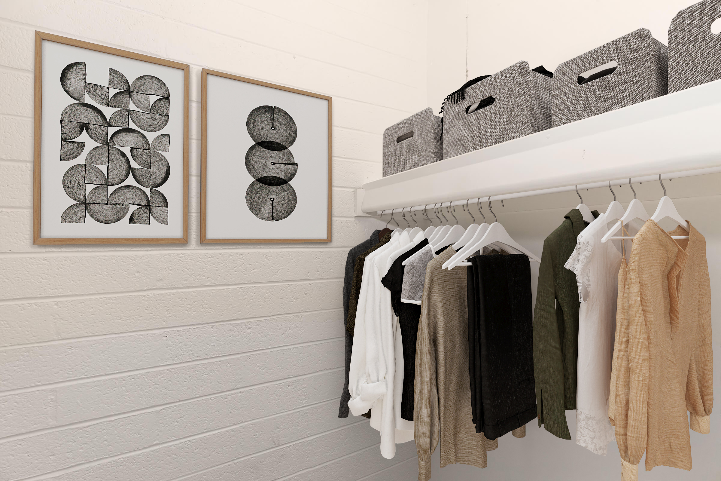 A neatly organized closet featuring two framed abstract black and white artworks on the wall. Below, a row of hangers displays various clothing items in neutral tones, including shirts and blouses. Above, gray storage boxes are neatly arranged on a shelf, enhancing the tidy and minimalist aesthetic.
