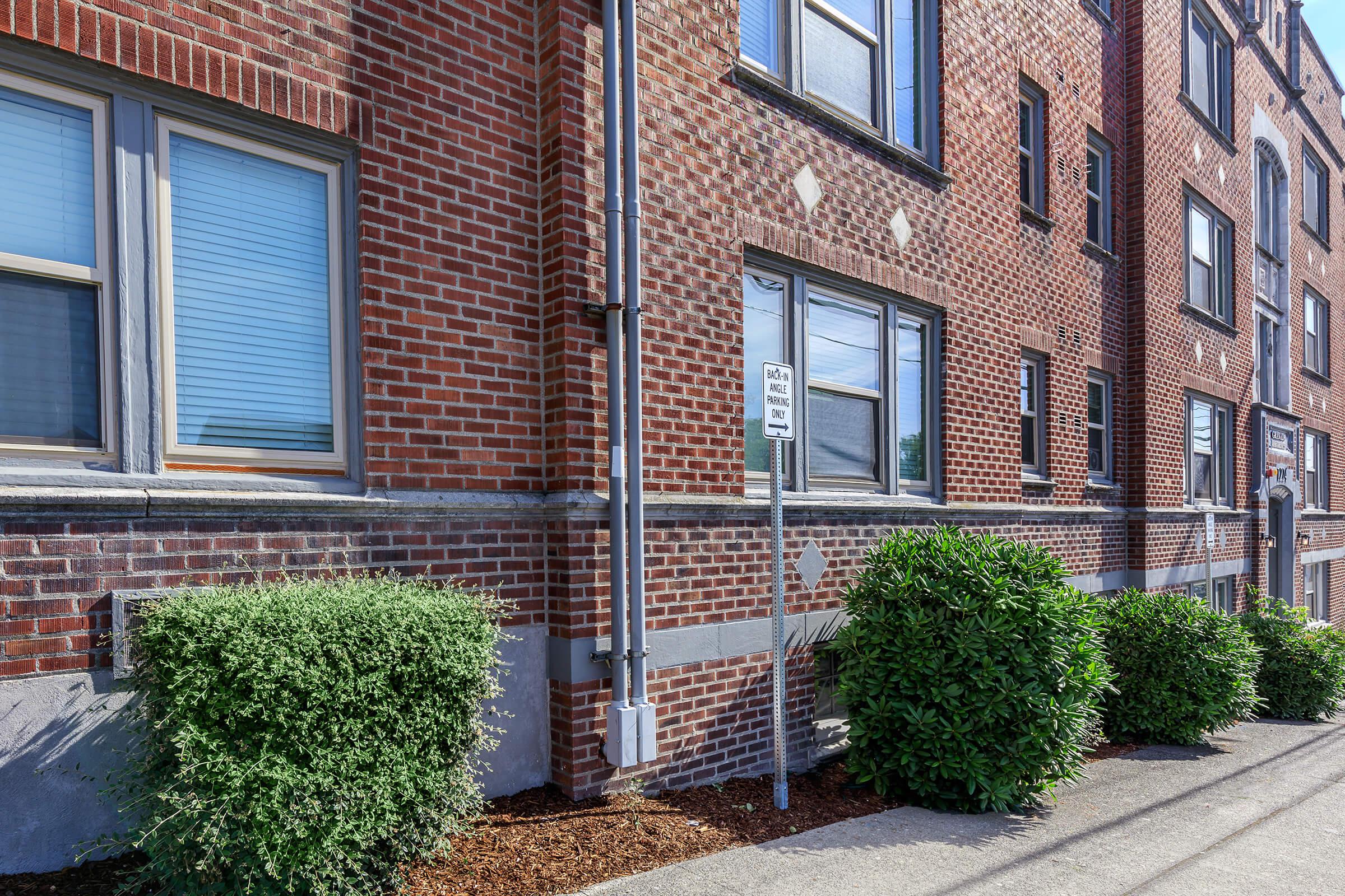 a garden in front of a brick building