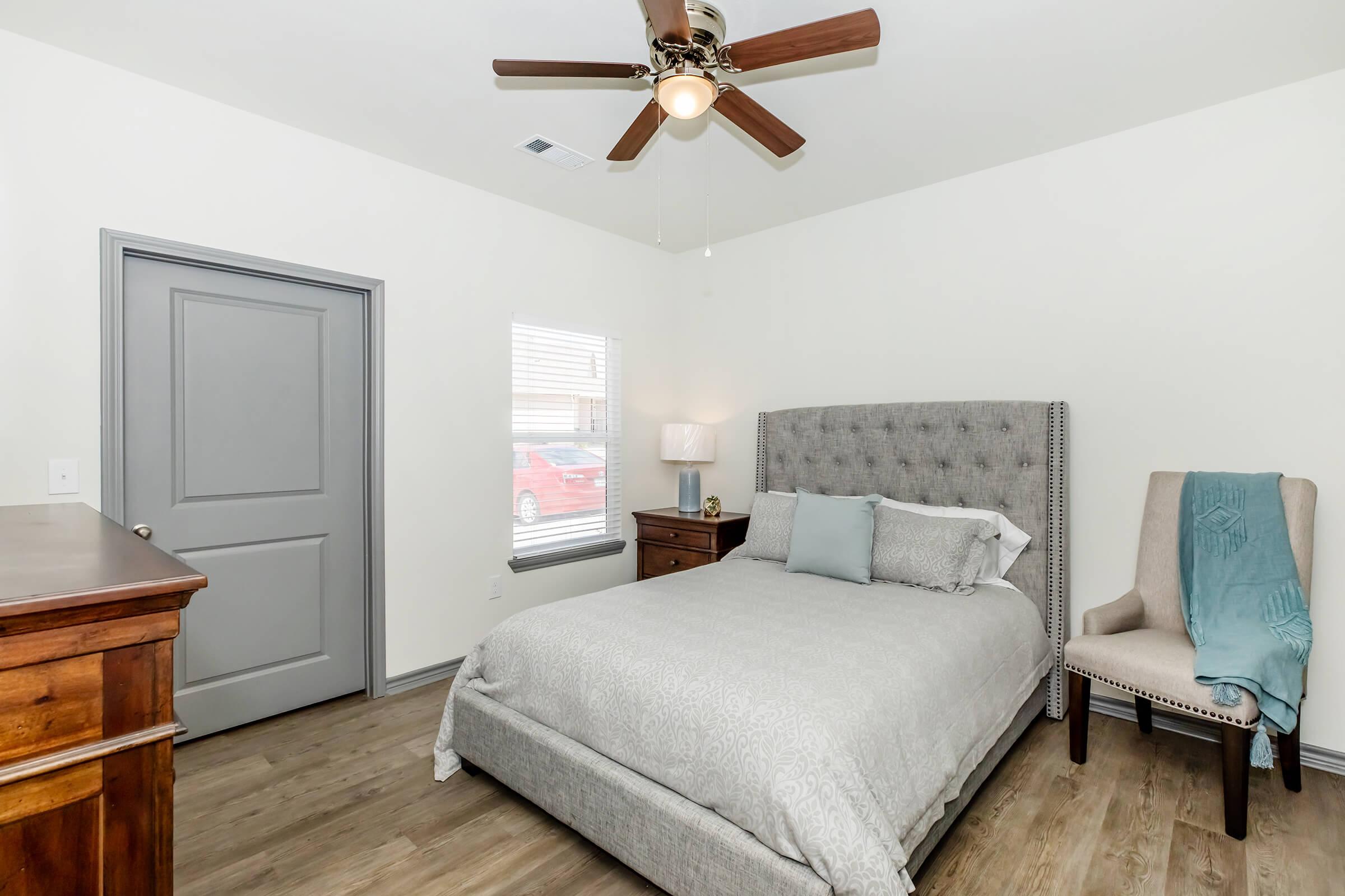 a bedroom with a bed and desk in a room