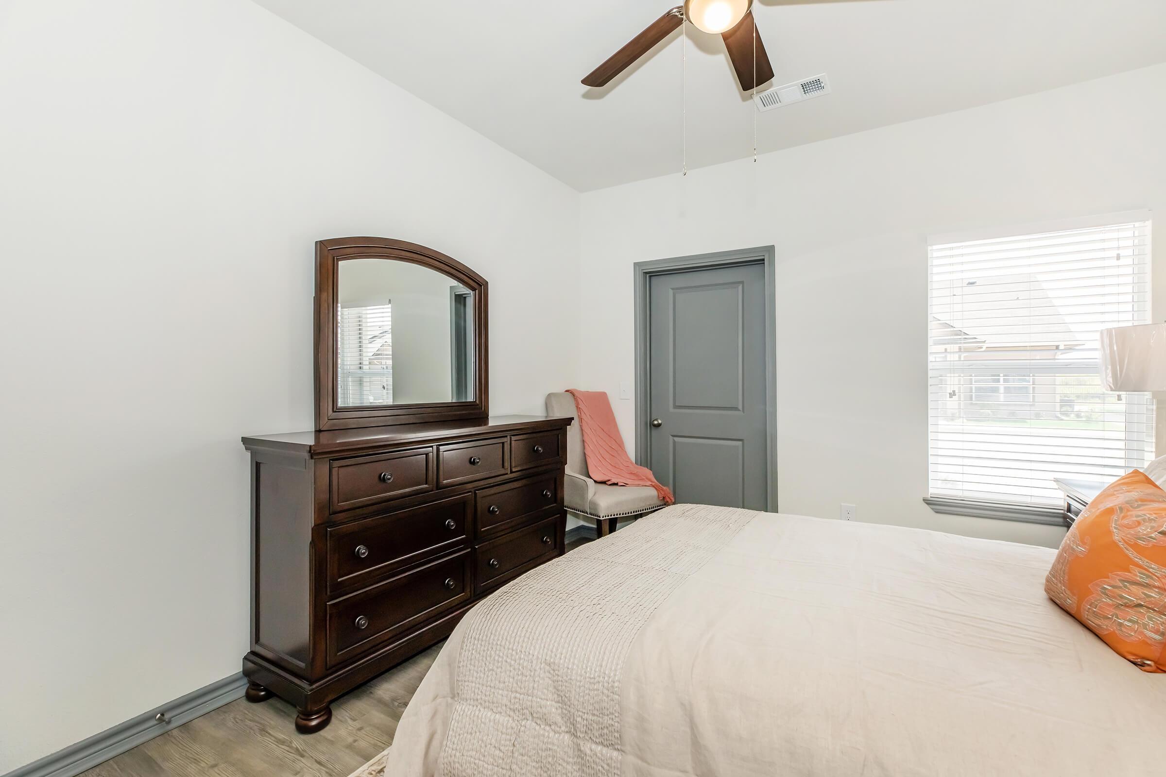 a bedroom with a bed and desk in a room