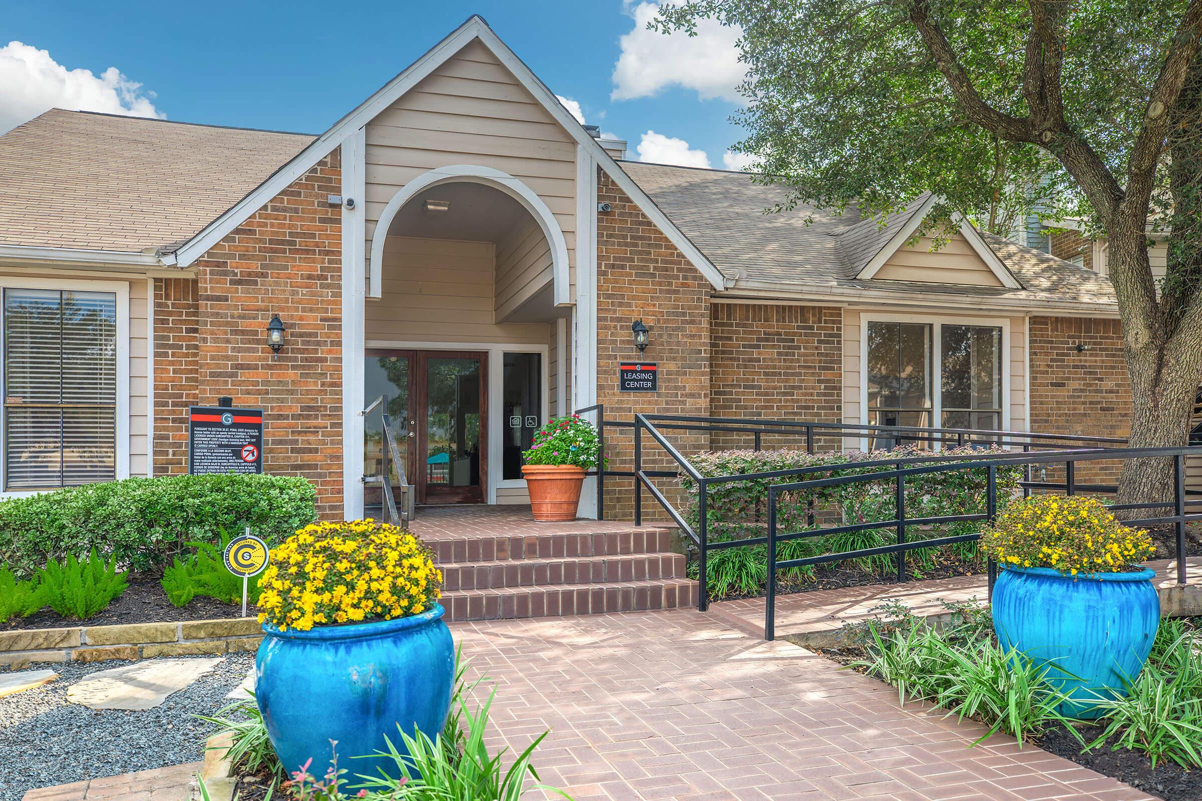 a house with bushes in front of a brick building