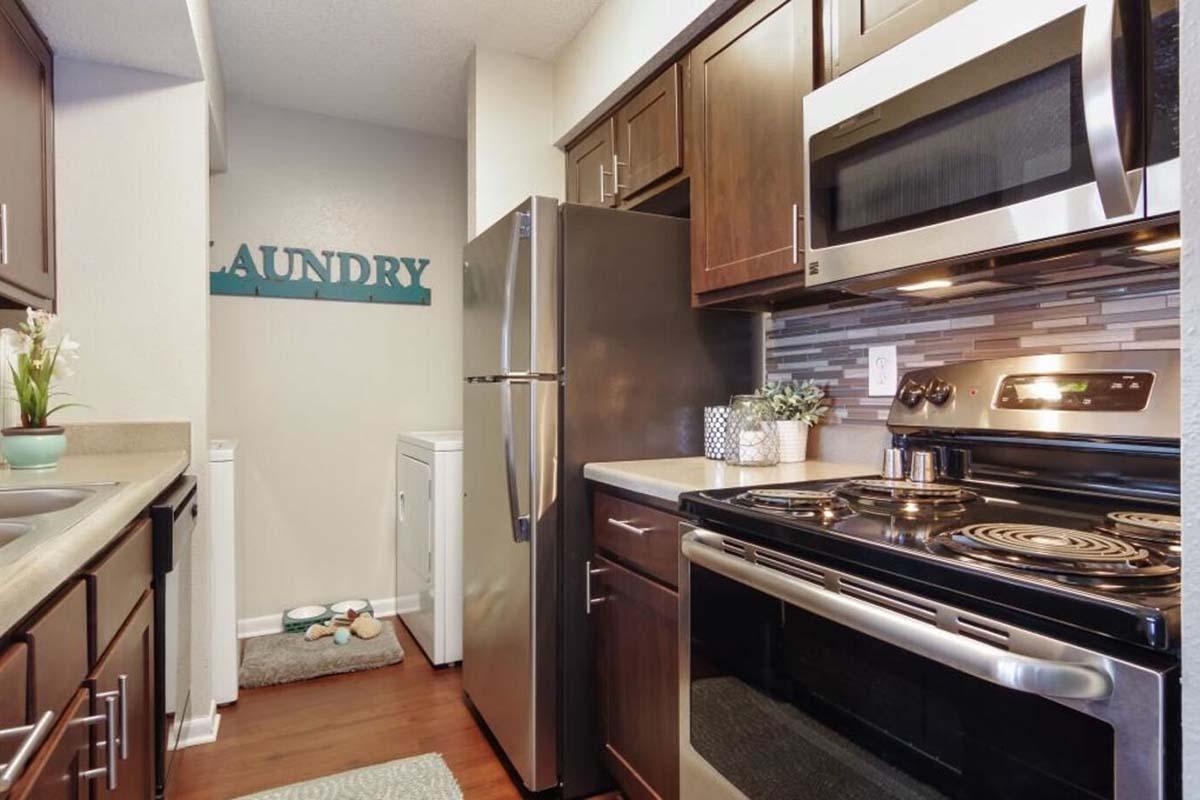 a stove top oven sitting inside of a kitchen with stainless steel appliances