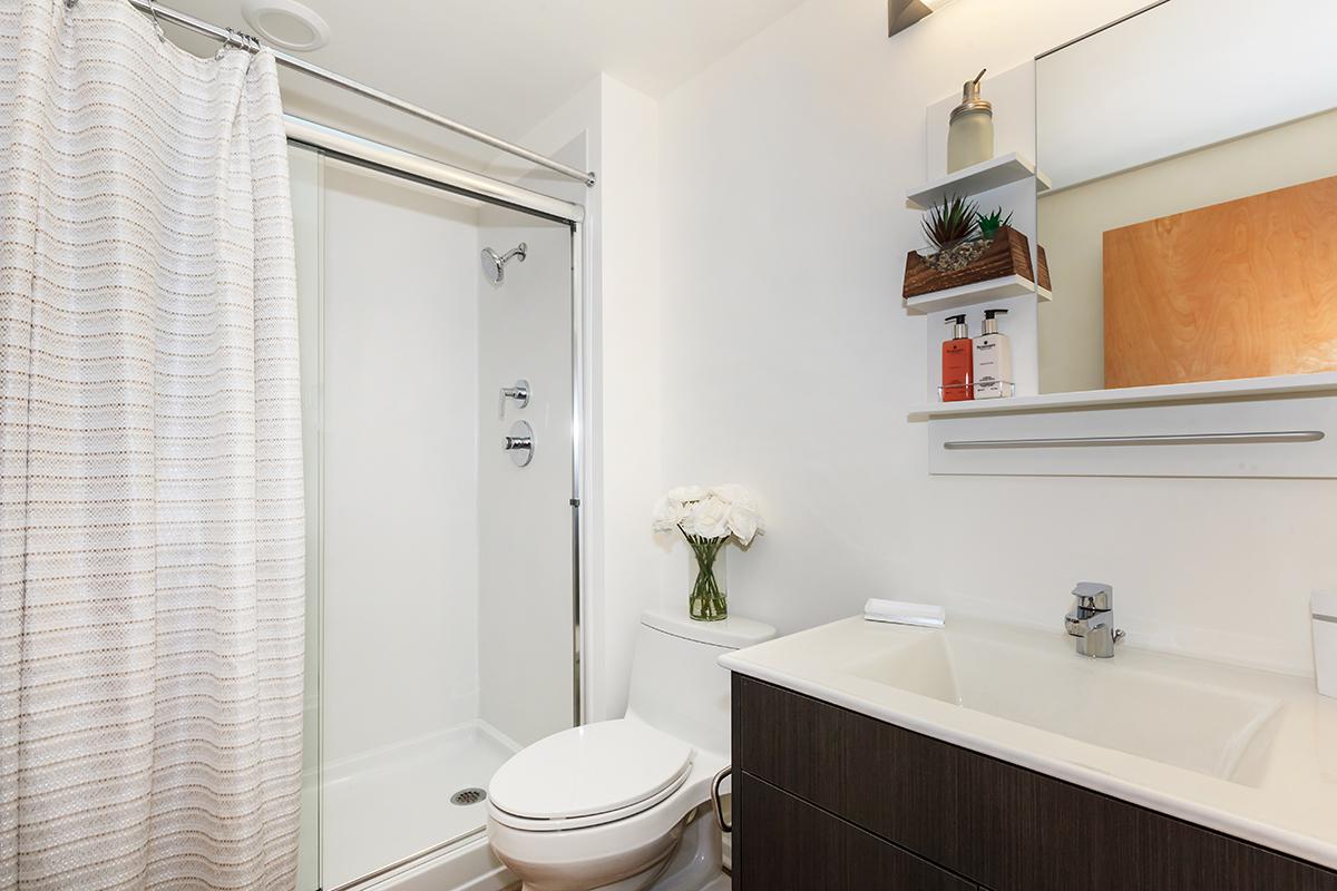 a white sink sitting next to a shower