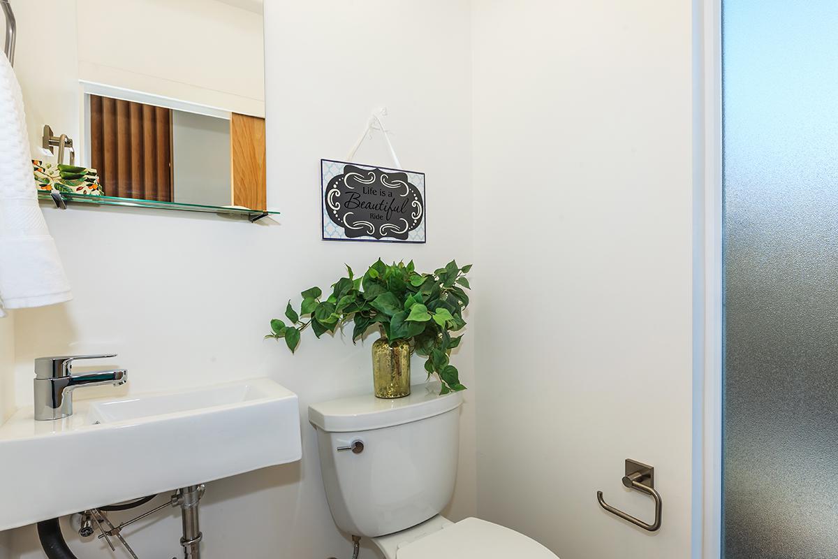 a white sink sitting under a mirror