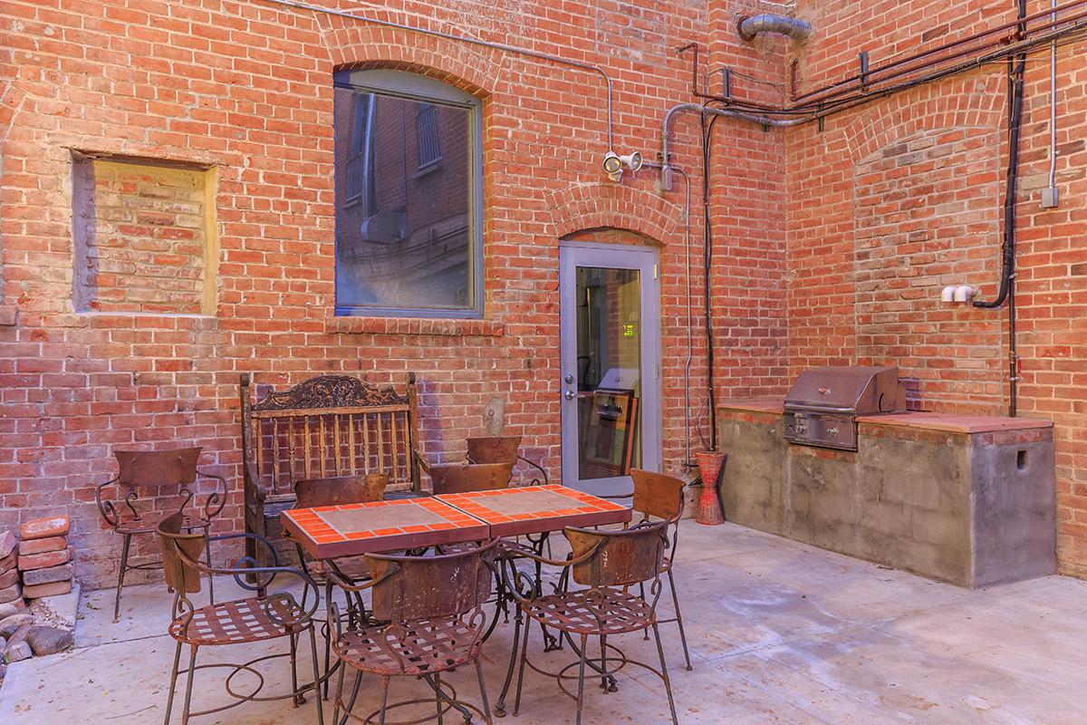 a fire place sitting in a chair in front of a brick building
