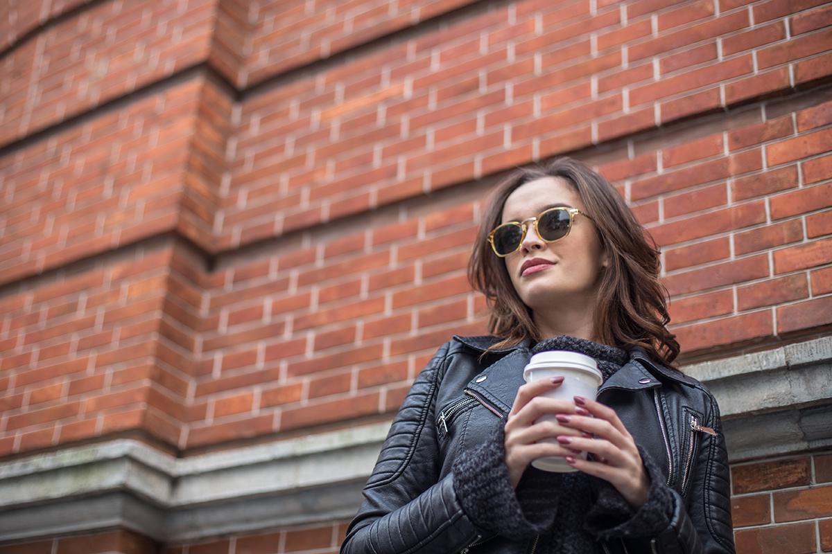 a woman standing in front of a brick building