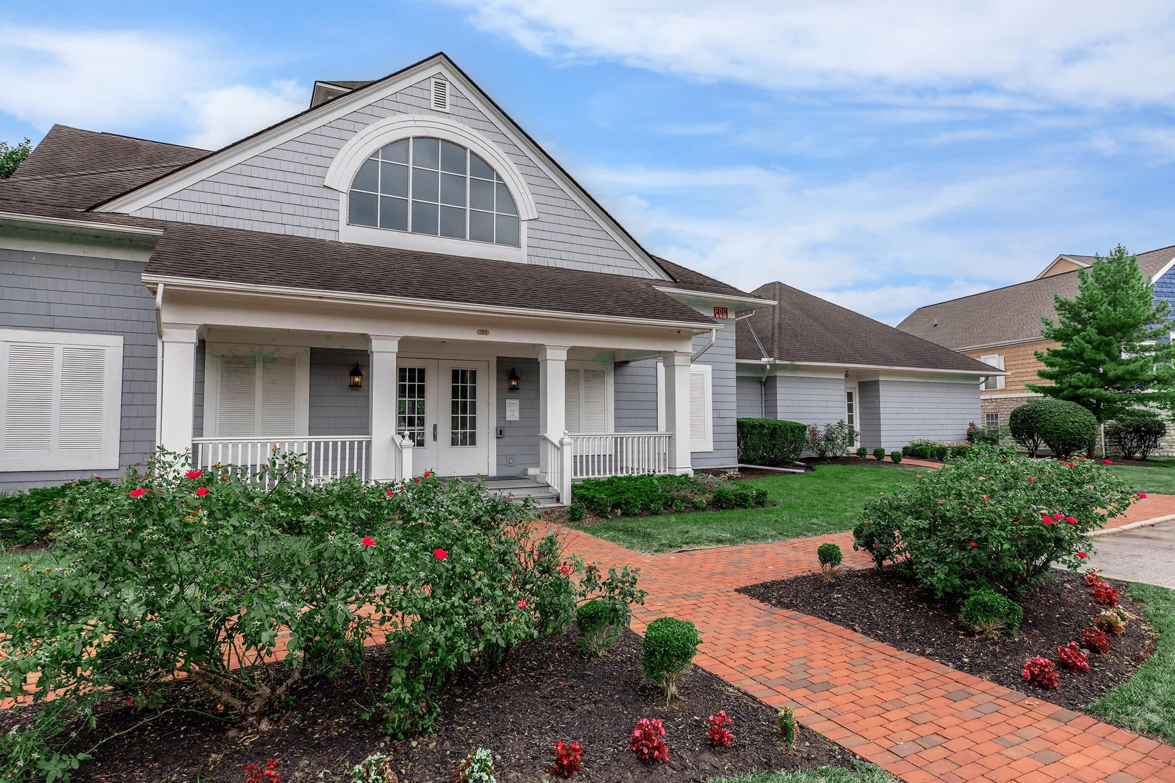 a close up of a flower garden in front of a house