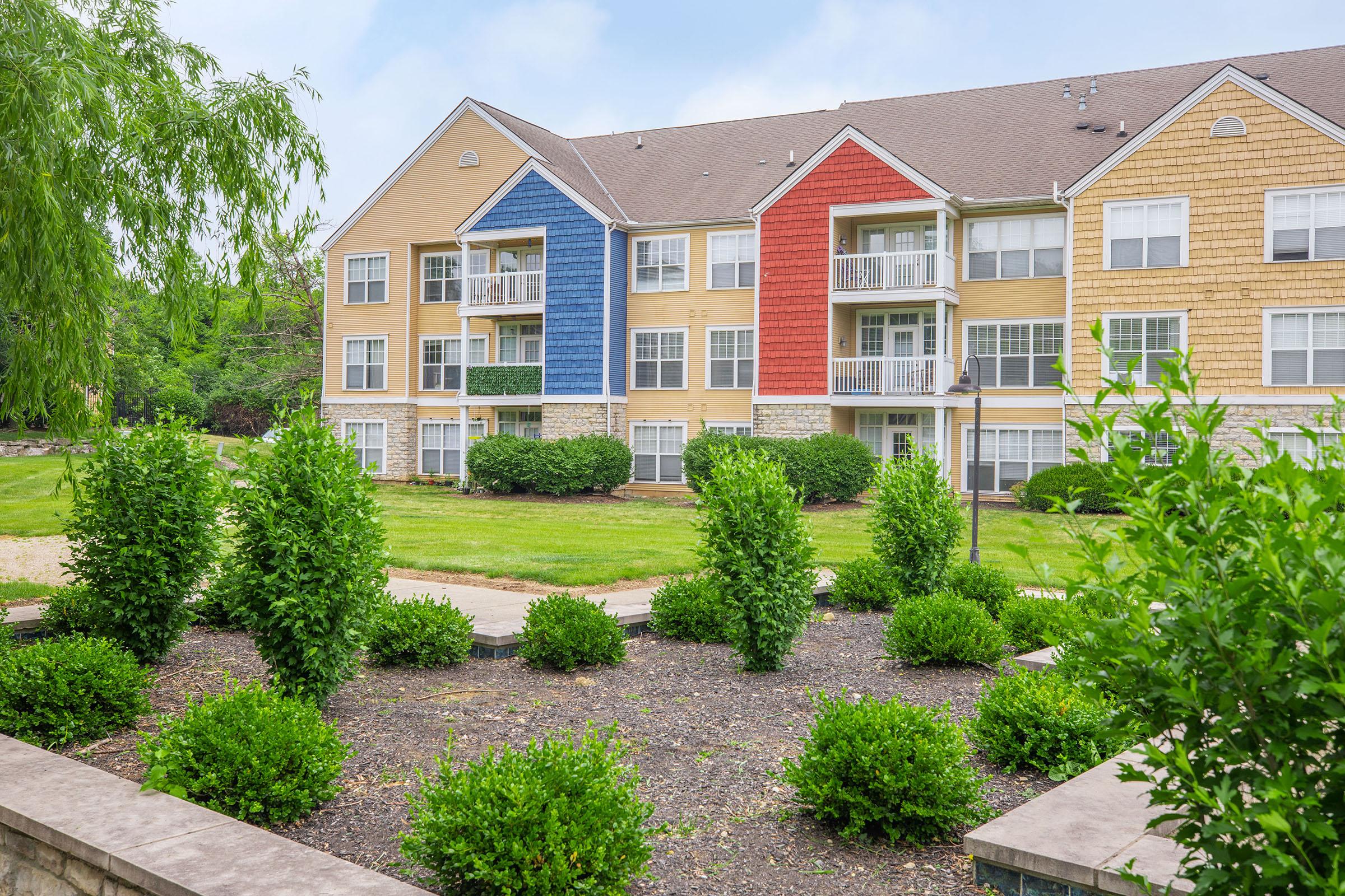 a house with bushes in front of a brick building