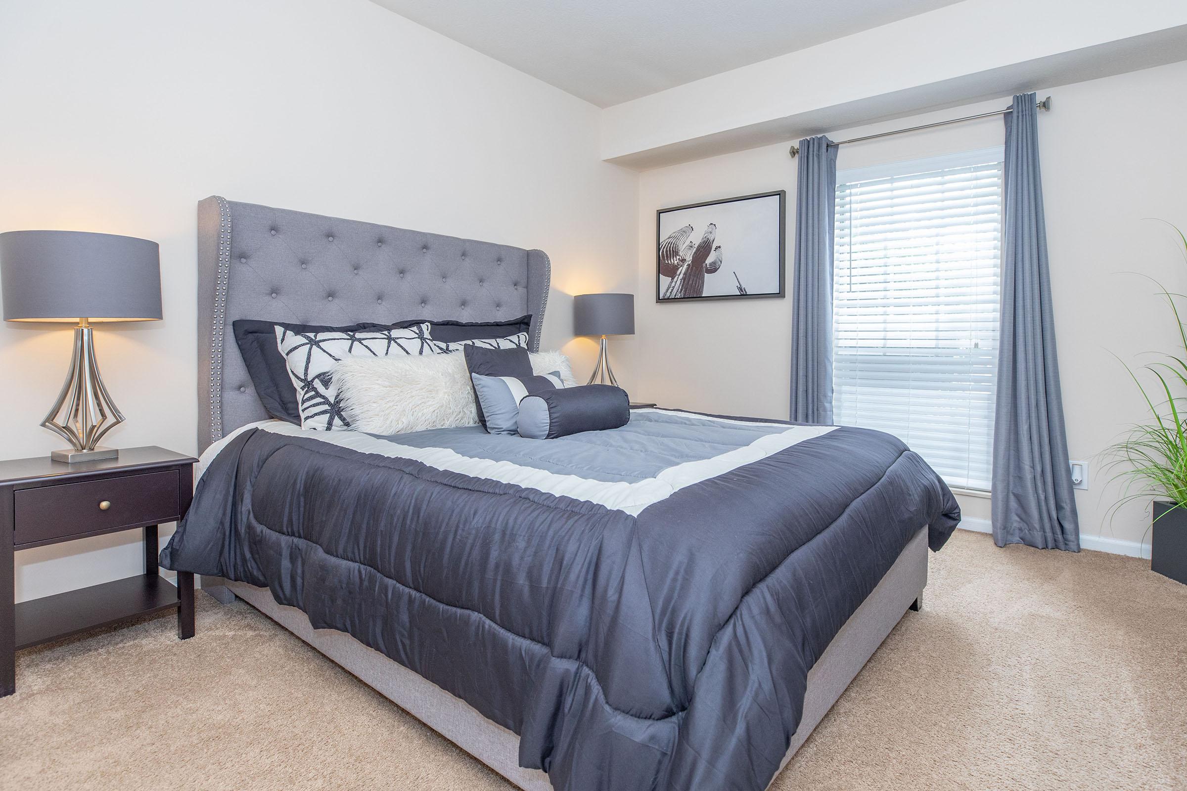 a bedroom with a bed and desk in a hotel room