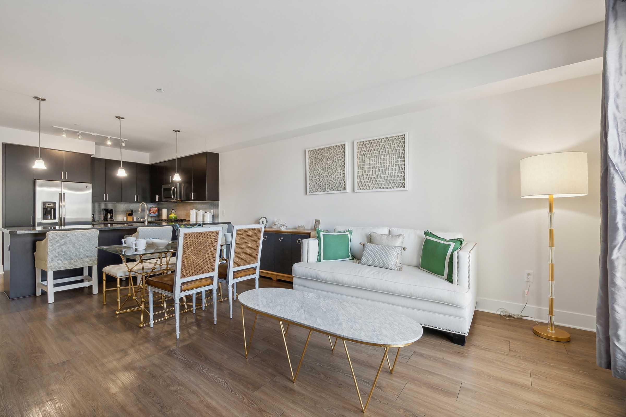 Modern living room with a white sofa adorned with green and patterned cushions.