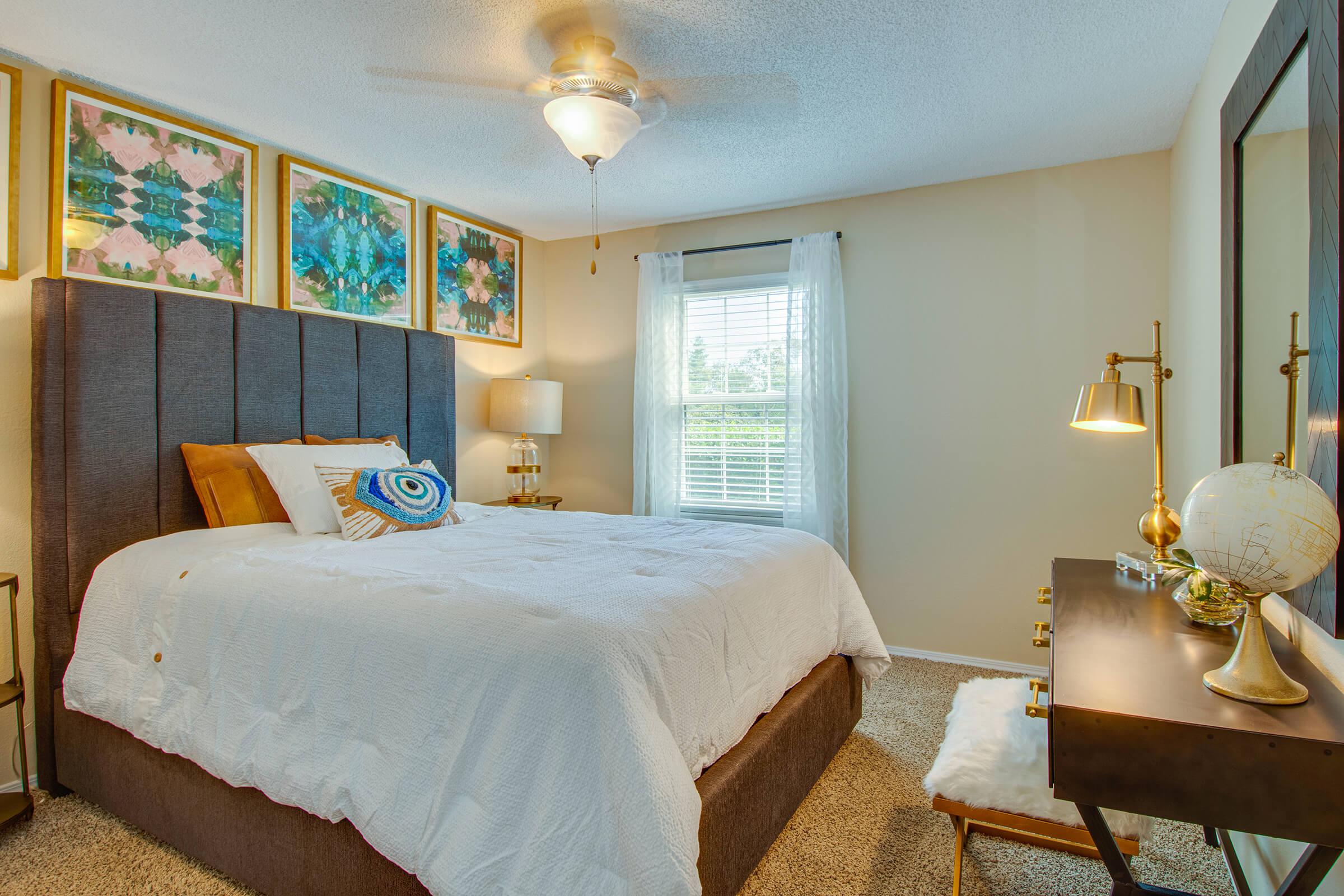 a bedroom with a bed and a chair in a room