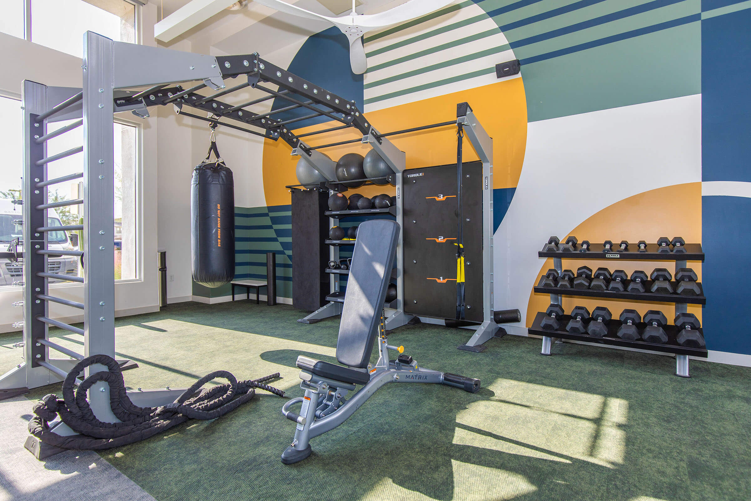 Fitness area with a punching bag, dumbbells and exercise bench.