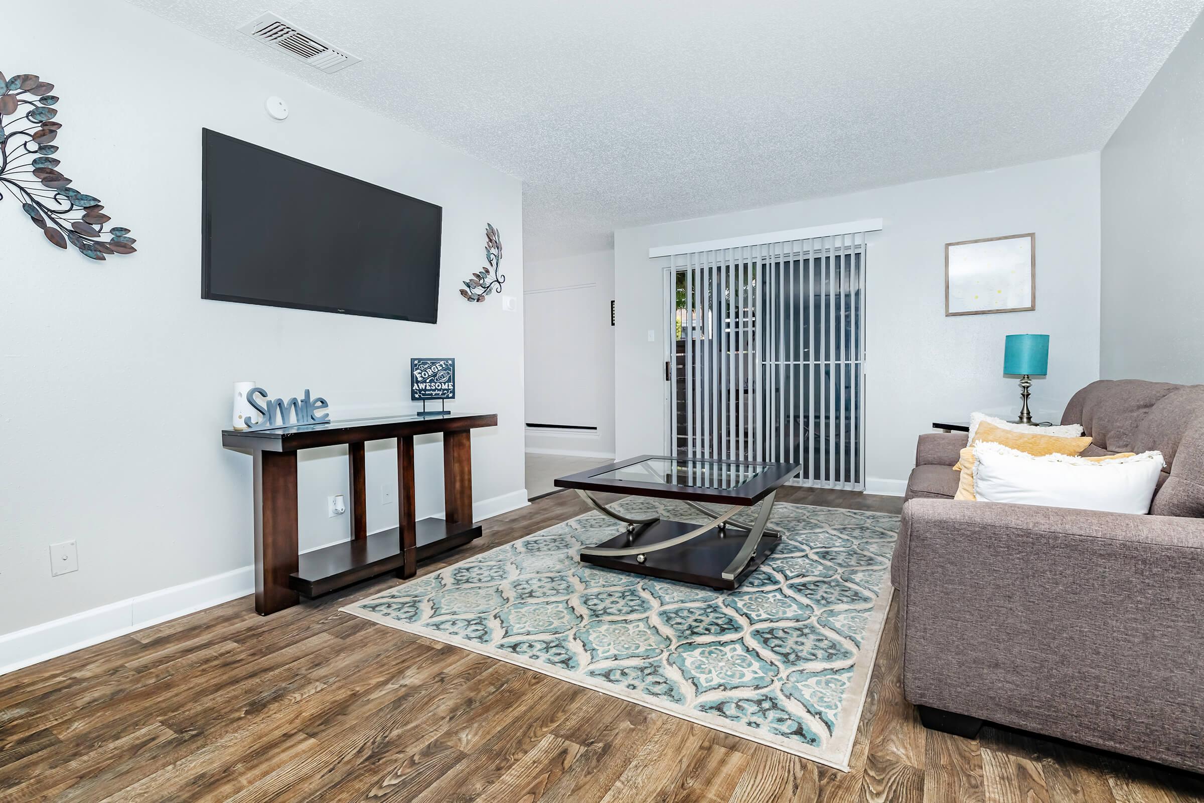 a living room filled with furniture and a flat screen tv