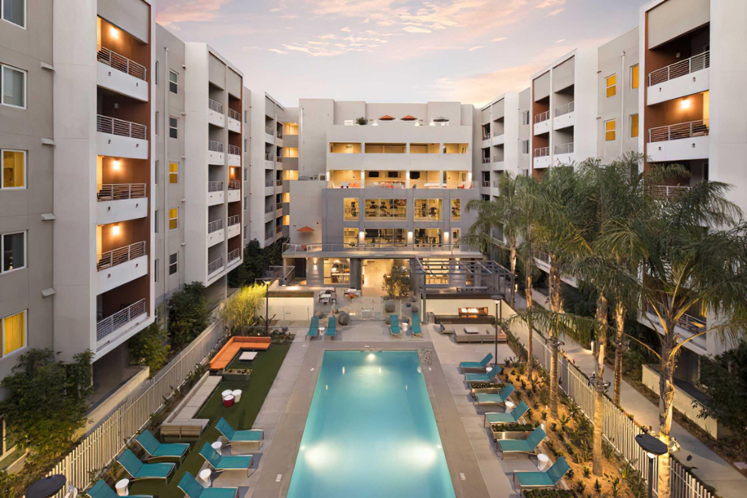 the view of a pool from a balcony at dusk