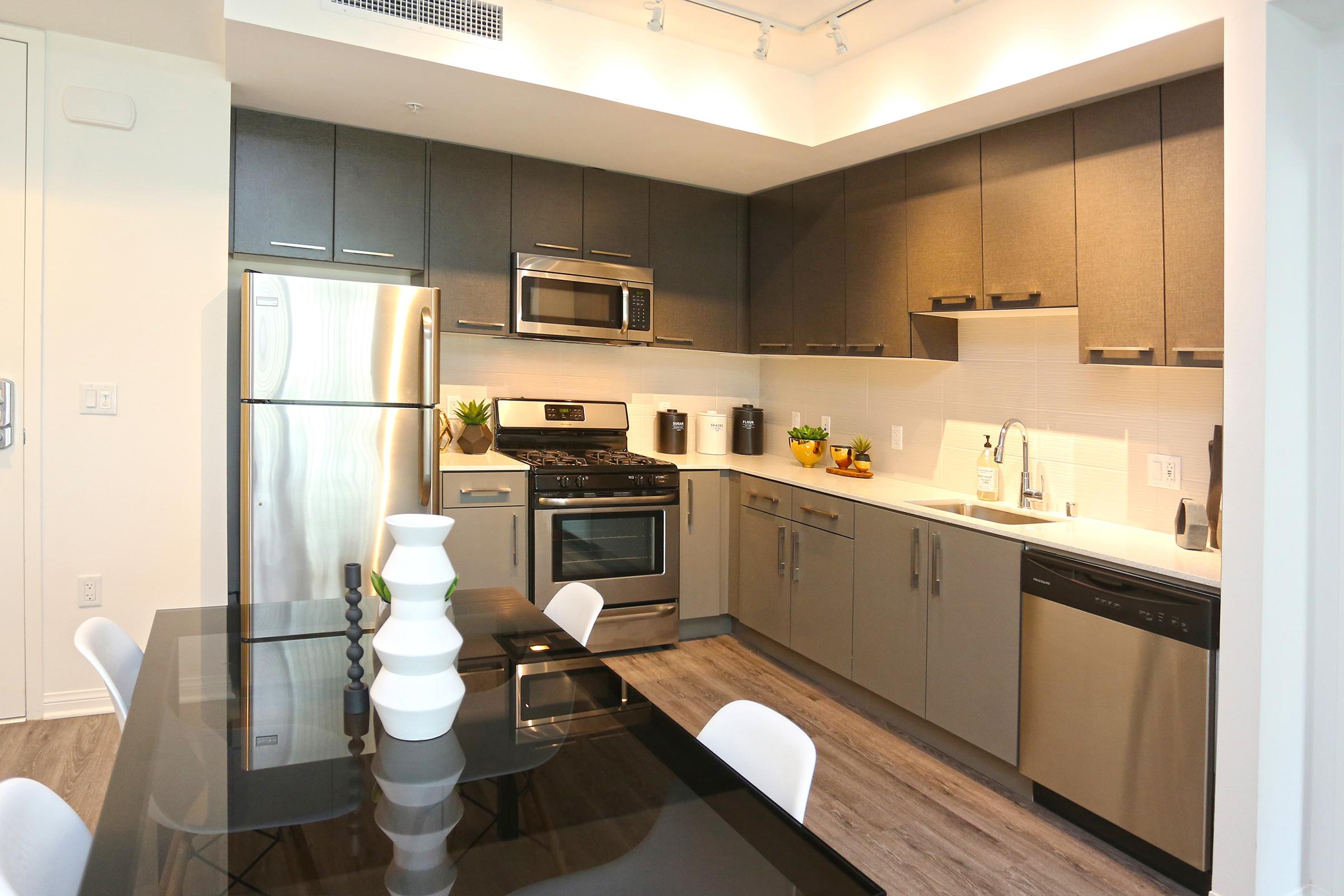 a kitchen with stainless steel appliances and gray cabinets