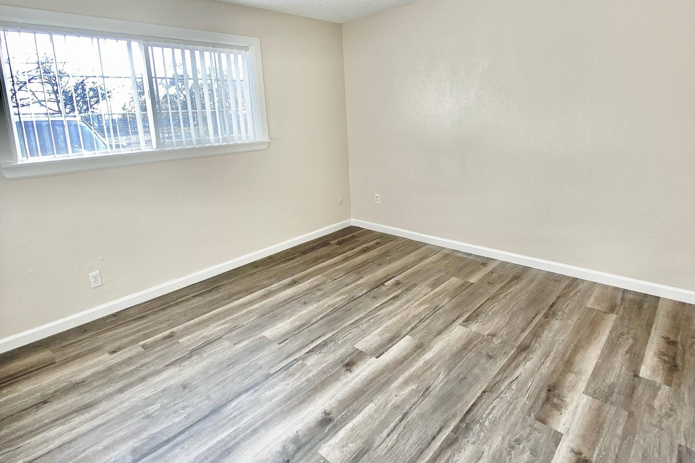 a wooden floor next to a window